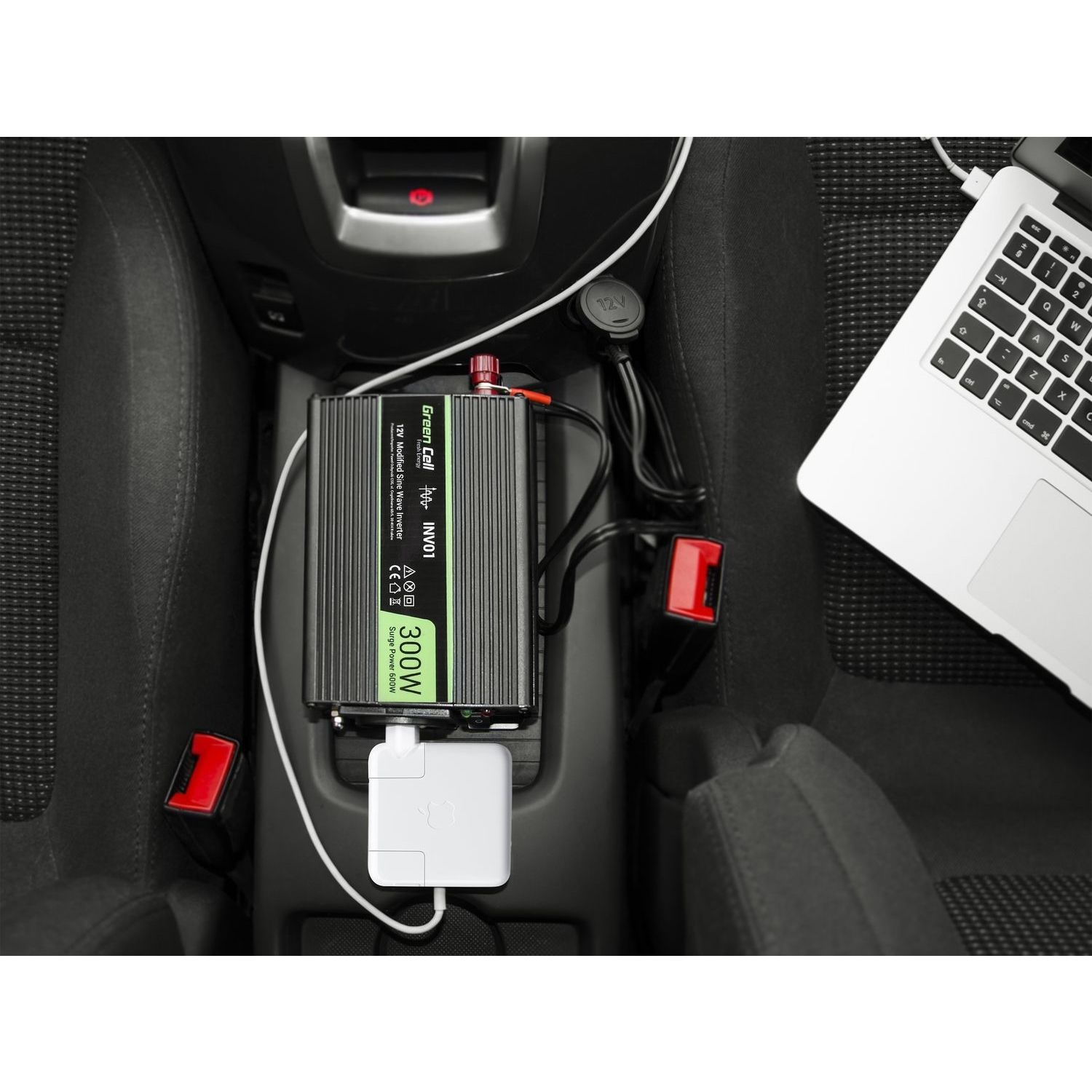 Wechselrichter im Auto. Ein Wechselrichter, ein Laptop und ein Ladegerät befinden sich in einem Auto und sind an die Steckdose angeschlossen.