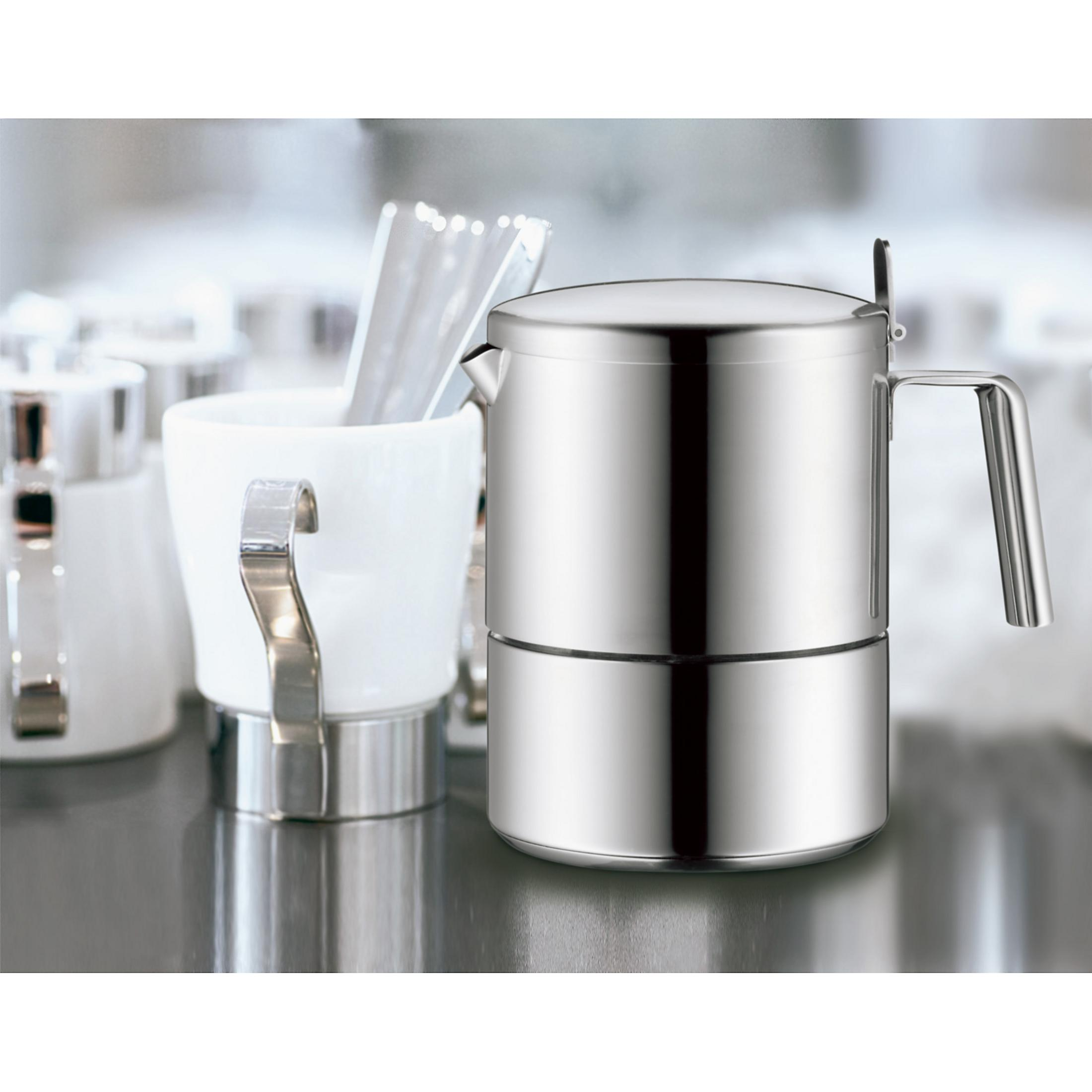 Kaffeemaschine aus Edelstahl und eine weiße Tasse mit Henkel. Weitere Tassen im Hintergrund.