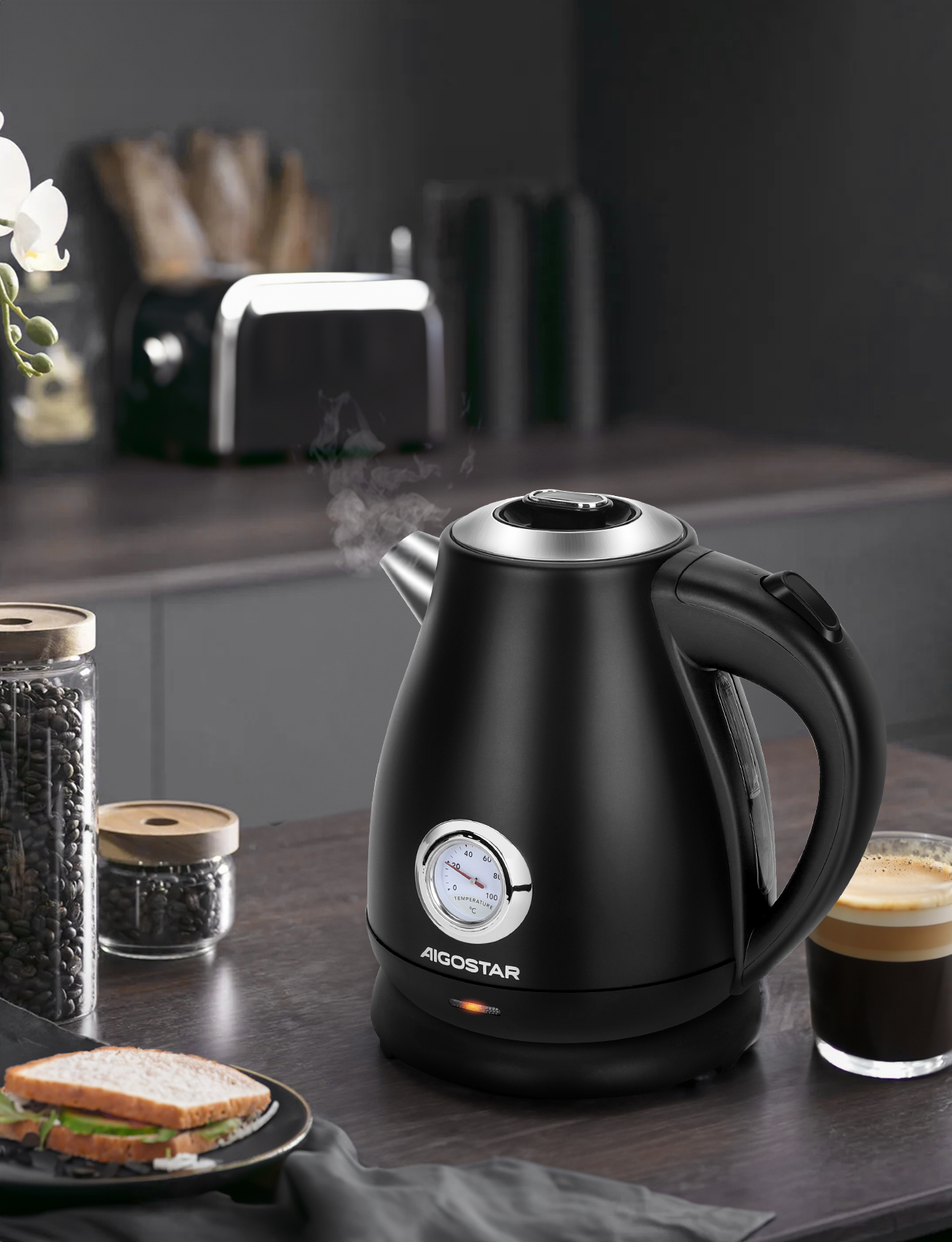 Bollitore nero, vapore che sale, con caffè e pane sul tavolo.