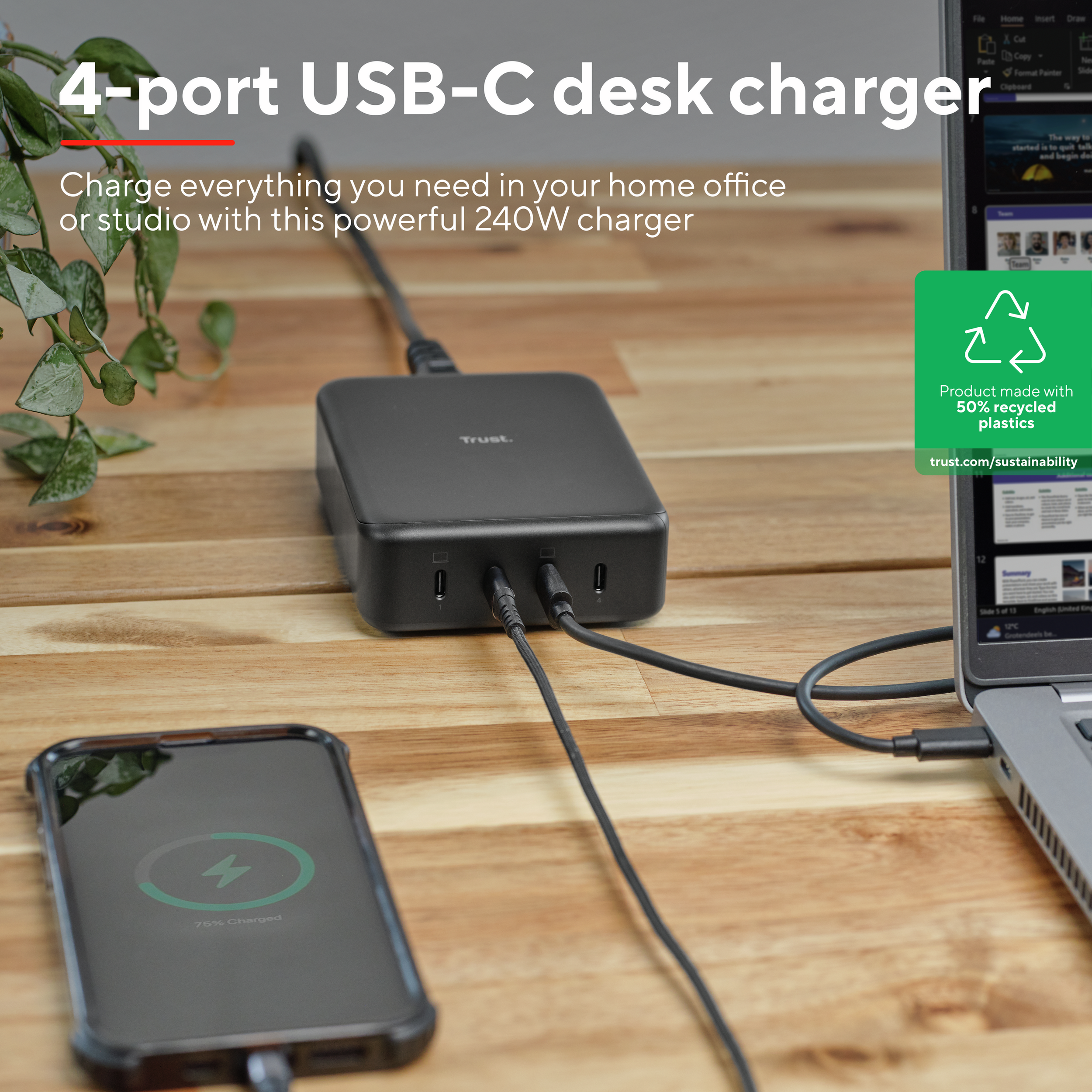 Een zwarte 4-poorts USB-C-oplader die een telefoon en laptop oplaadt. Tekst: product gemaakt met 50% gerecycled plastic.