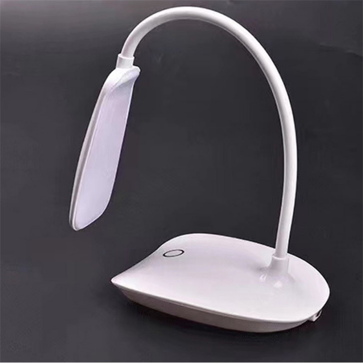 Weiße Schreibtischlampe mit gebogenem Hals und ovaler Lichtfläche, auf weißem Sockel.
