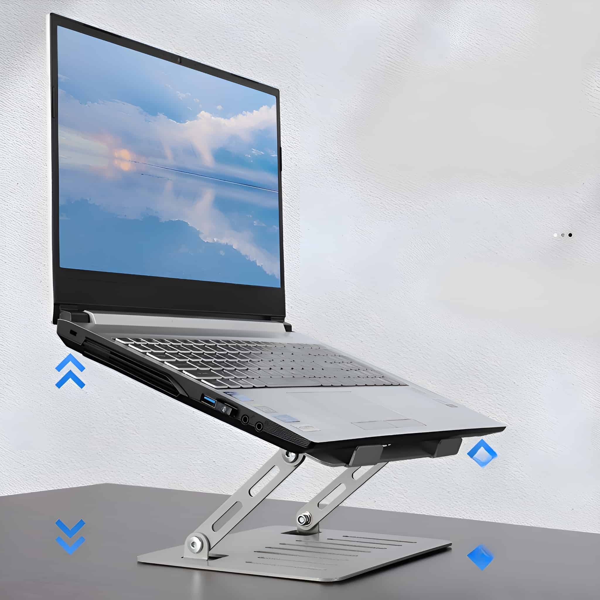 Laptop auf silbernem Ständer, angewinkelt, blaue Pfeile zeigen die Einstellung, graue Oberfläche.