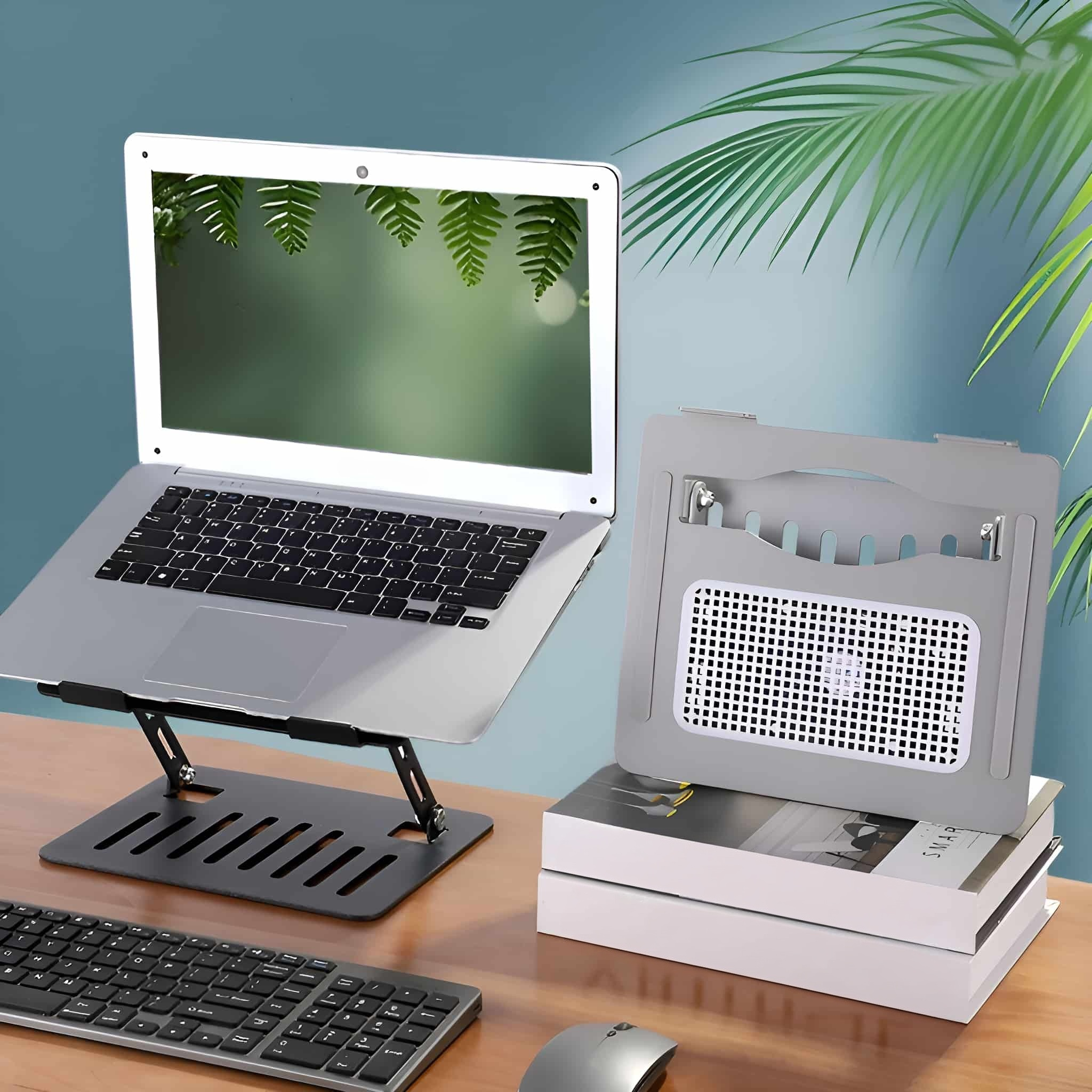 Laptop auf Ständer mit Tastatur, Maus und Kühlpad auf dem Schreibtisch.