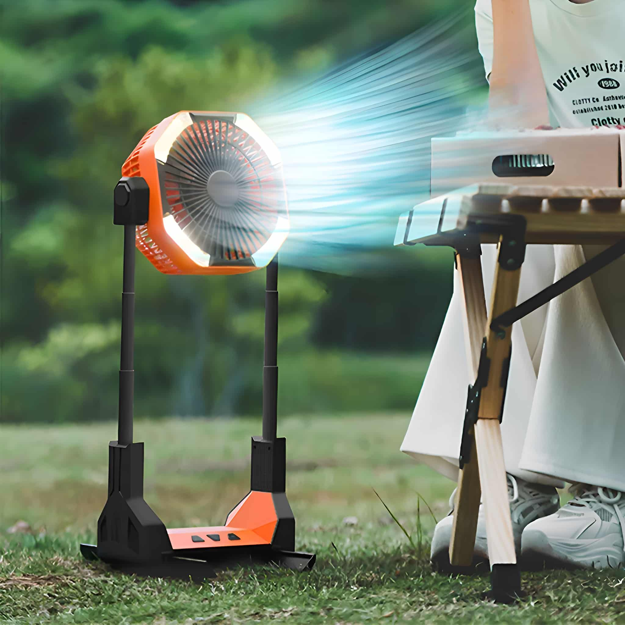Orangener und schwarzer tragbarer Ventilator, der ein helles Licht aussendet. Eine Person ist in der Nähe.