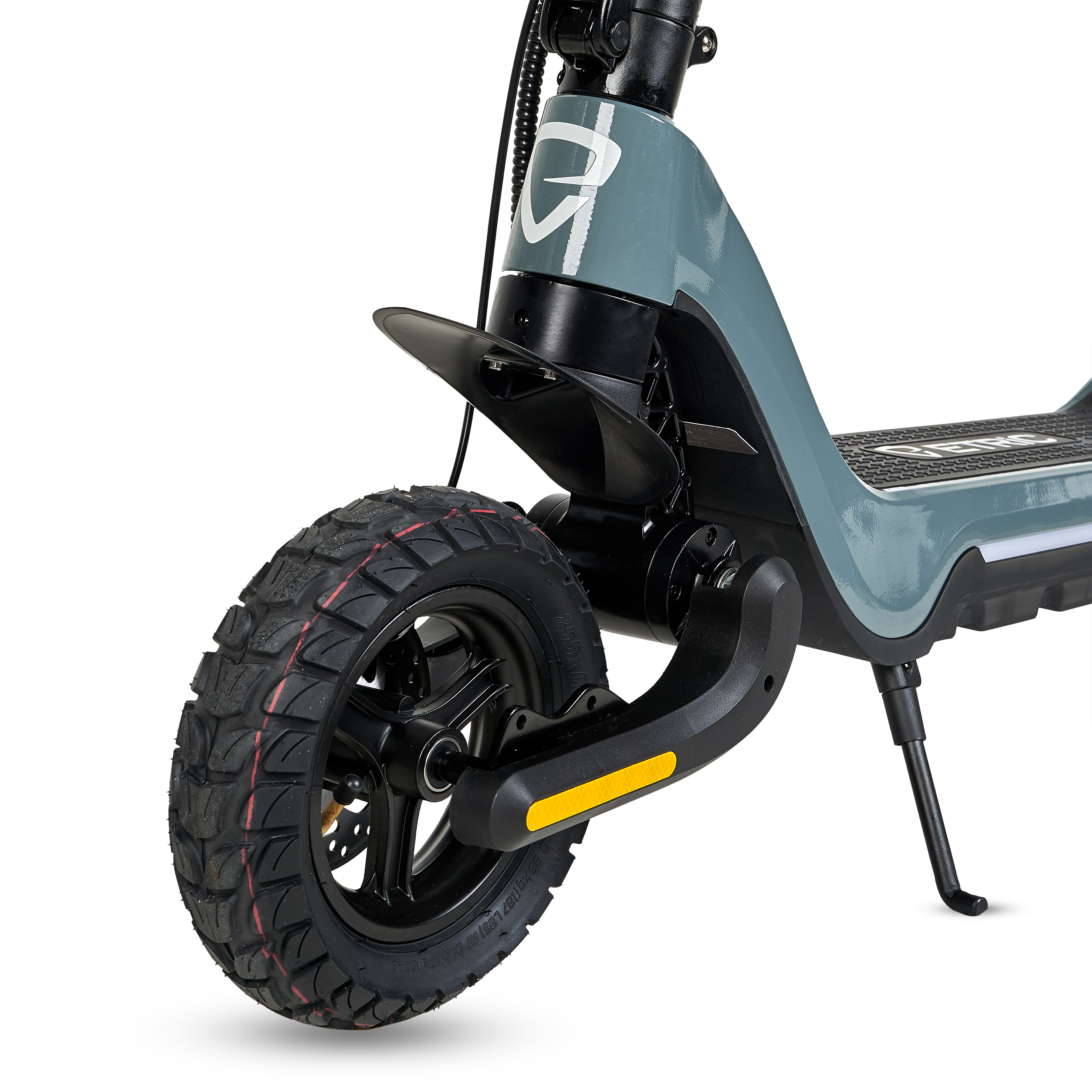 Primer plano de la rueda de un patinete eléctrico gris. Tiene un neumático negro, un guardabarros negro y una pata de cabra.