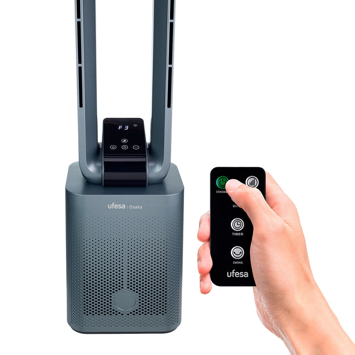 Szary wentylator wieżowy z pilotem. Ręka trzyma pilota, pokazując przyciski. Białe tło.