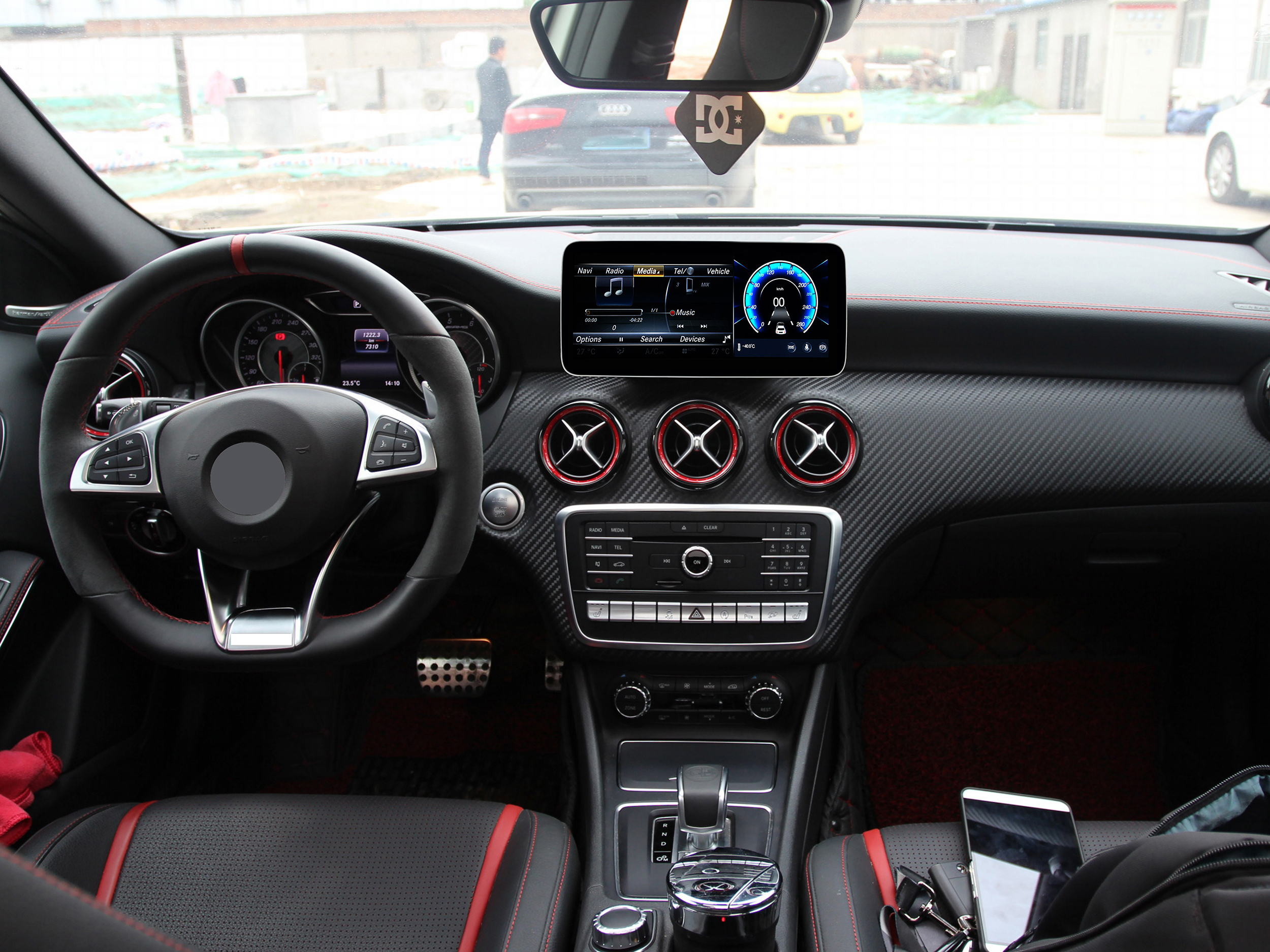 Autoinnenraum mit Armaturenbrett. Lenkrad, Infotainment-Bildschirm und rote Akzente.