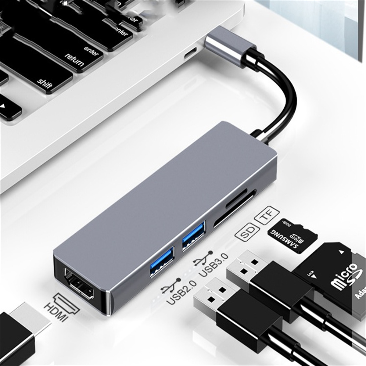 Ein grauer USB-Hub mit Anschlüssen, an einen Laptop angeschlossen.