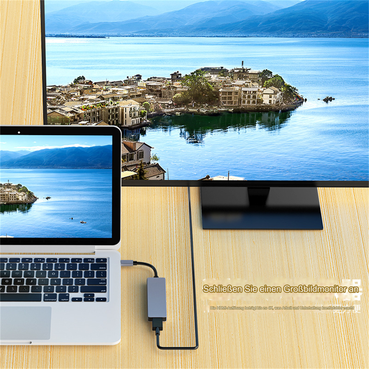Laptop an Monitor angeschlossen, der Landschaft zeigt. Der Laptop steht auf Holz.