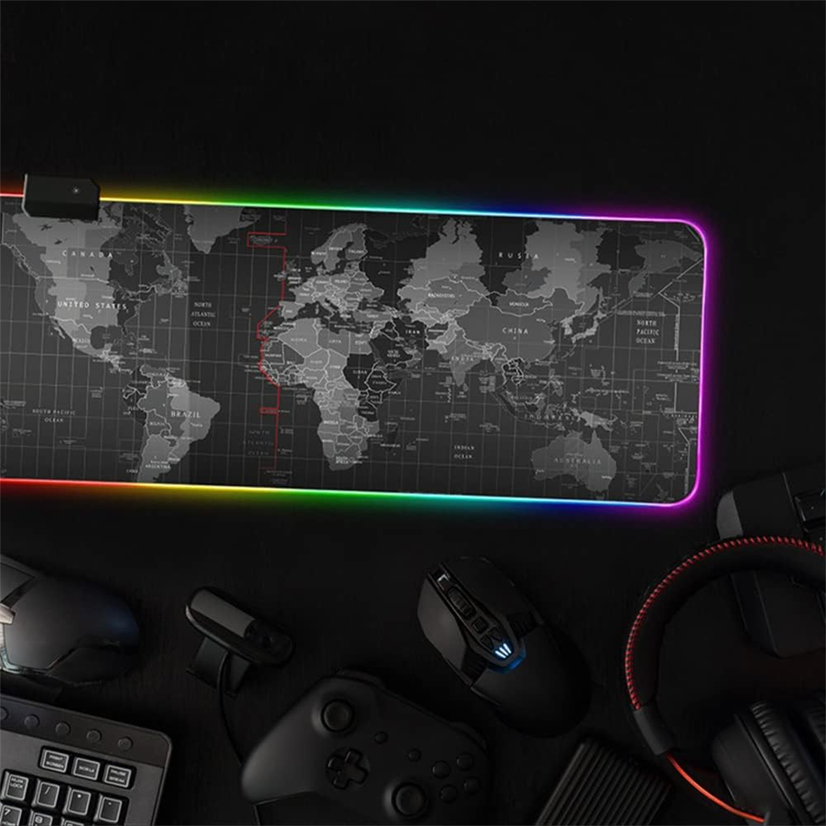 Schwarzes Gaming-Mauspad mit Weltkarten-Design und RGB-Beleuchtung. Maus, Tastatur und Headset.