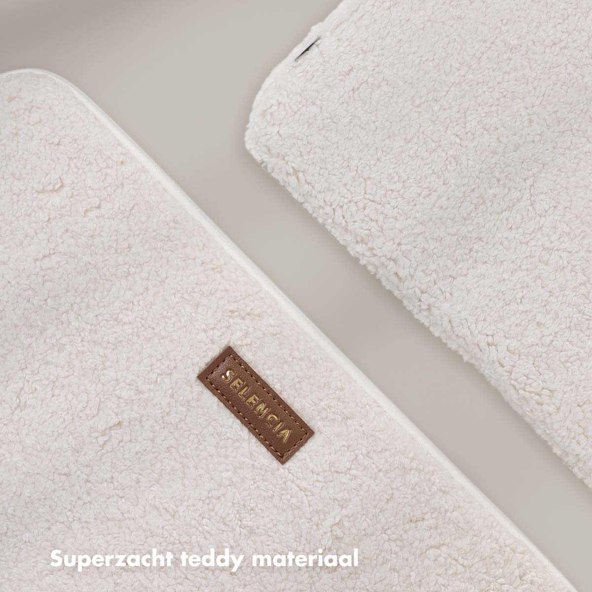 Two white fluffy pillows with a brown label that reads 'SELENCIA.' The text 'Superzacht teddy materiaal' is below.