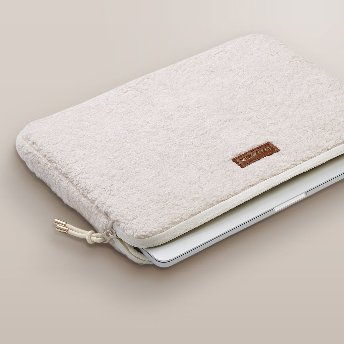 White laptop case with a laptop inside. The case is fuzzy and the zipper is open.
