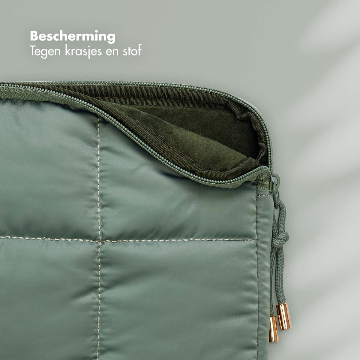 Quilted green laptop sleeve with a zipper. Inside is dark green.