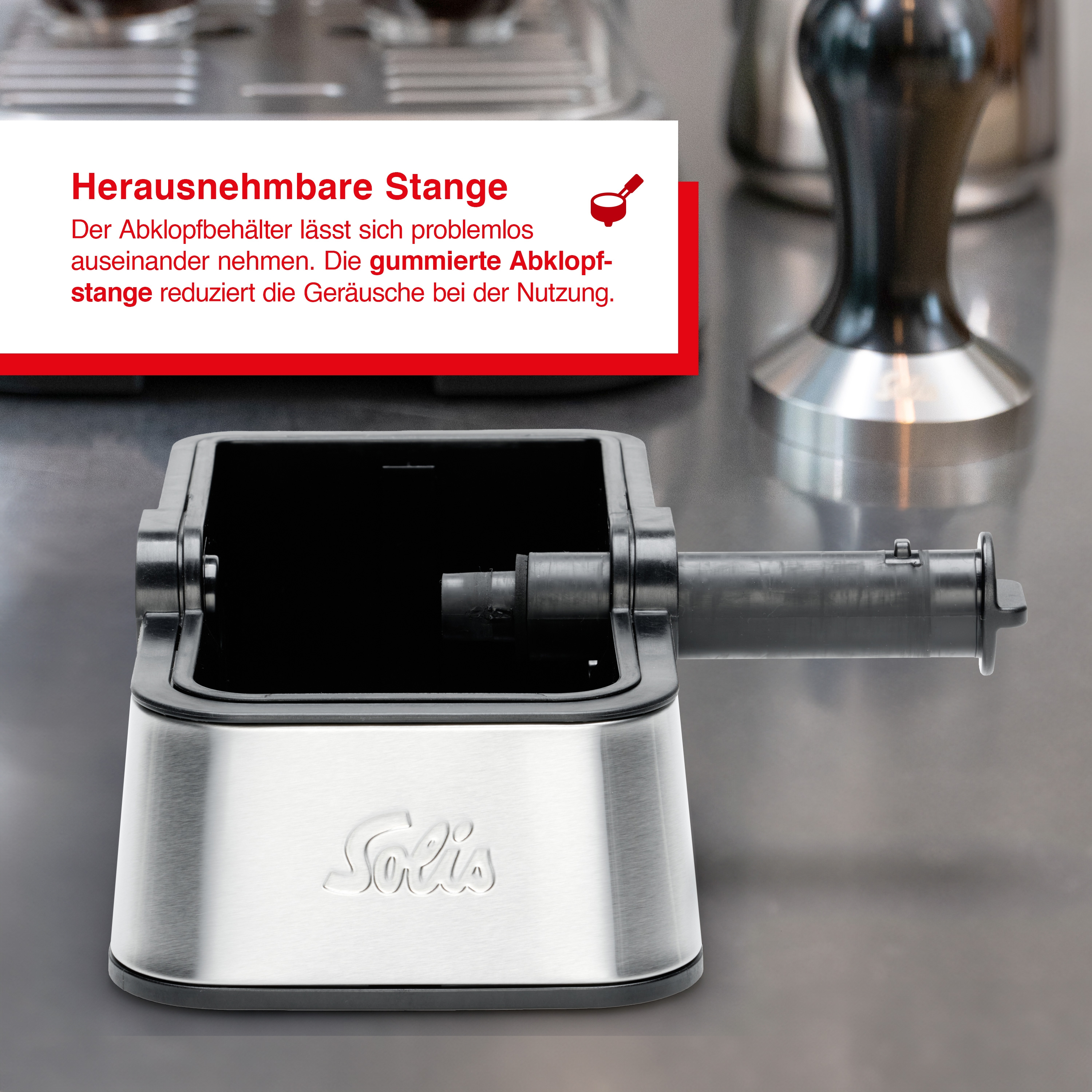 Edelstahl-Kaffeemaschinenteil mit herausnehmbarer Abschlagbox. Text beschreibt die Box und ihre Geräuschreduzierungsfunktion.