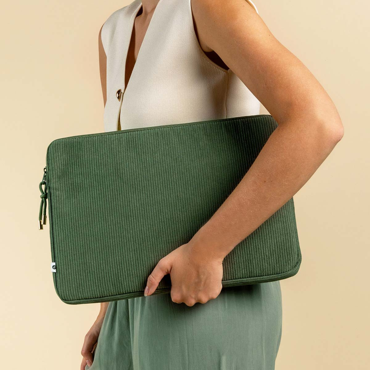 A woman holding a green corduroy laptop sleeve.