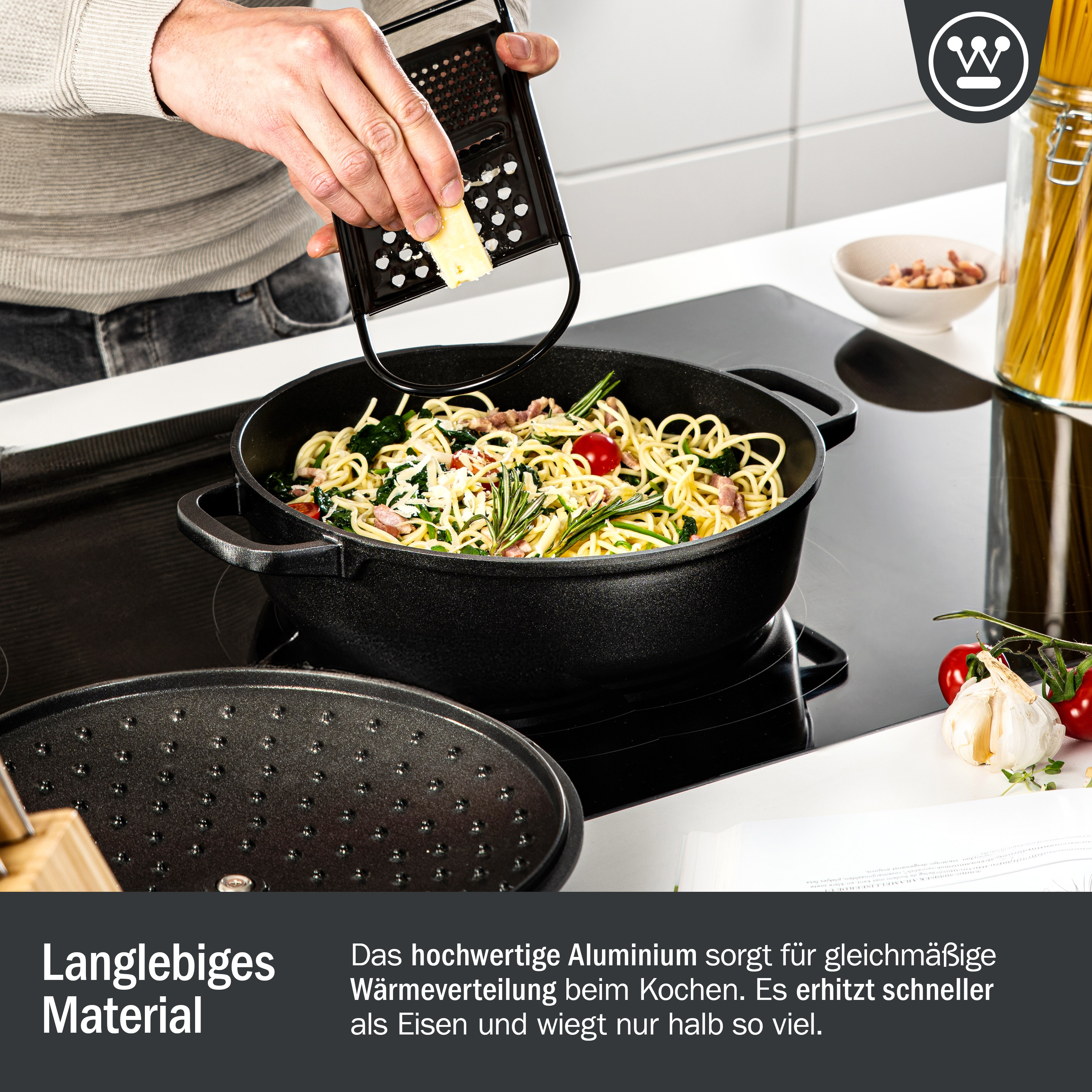 Eine Person reibt Käse in eine Pfanne mit Nudeln und Gemüse. Text über die Materialqualität ist vorhanden.