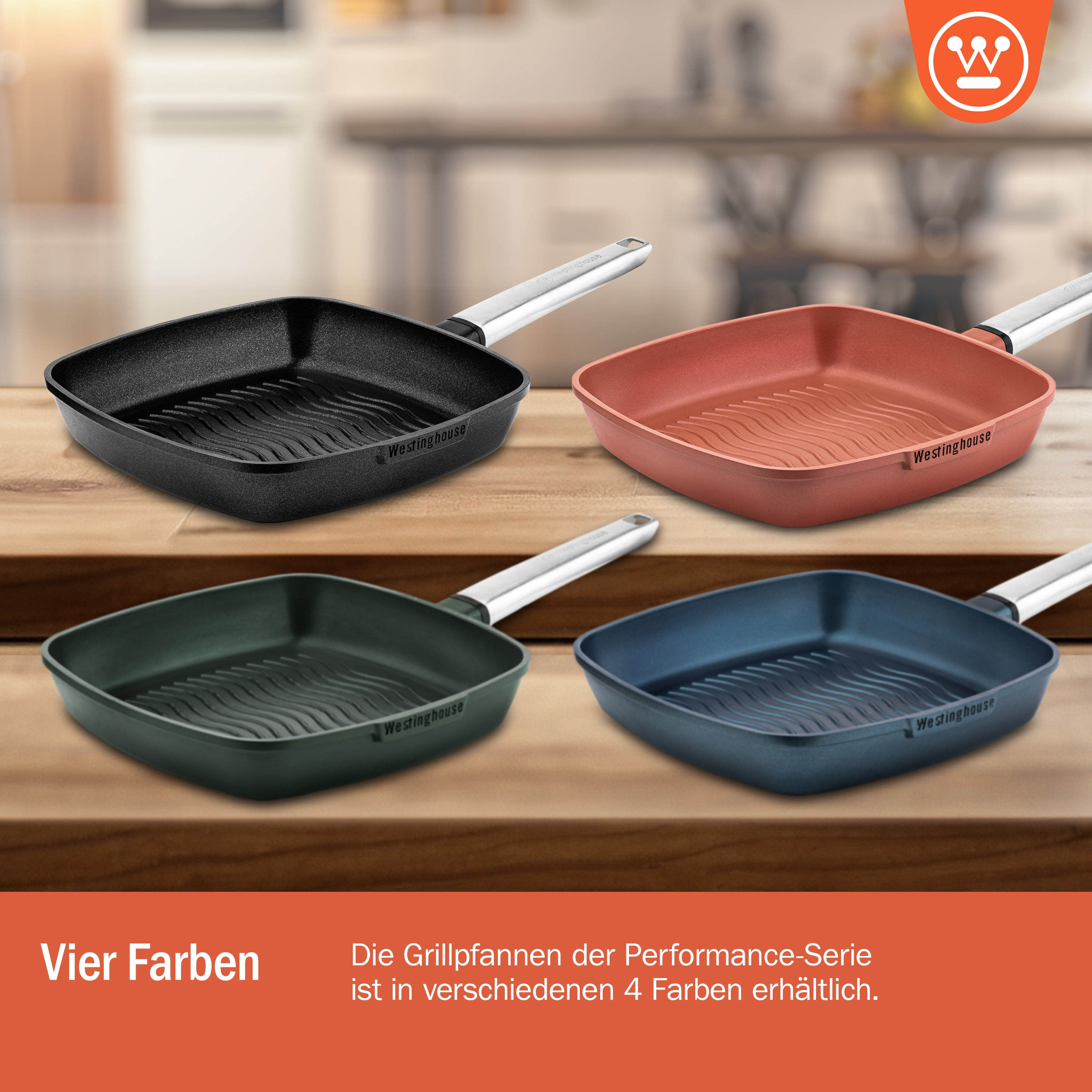 Vier quadratische Pfannen in verschiedenen Farben: schwarz, rot, grün und blau, auf einem Holztisch. Der Hintergrund ist orange.