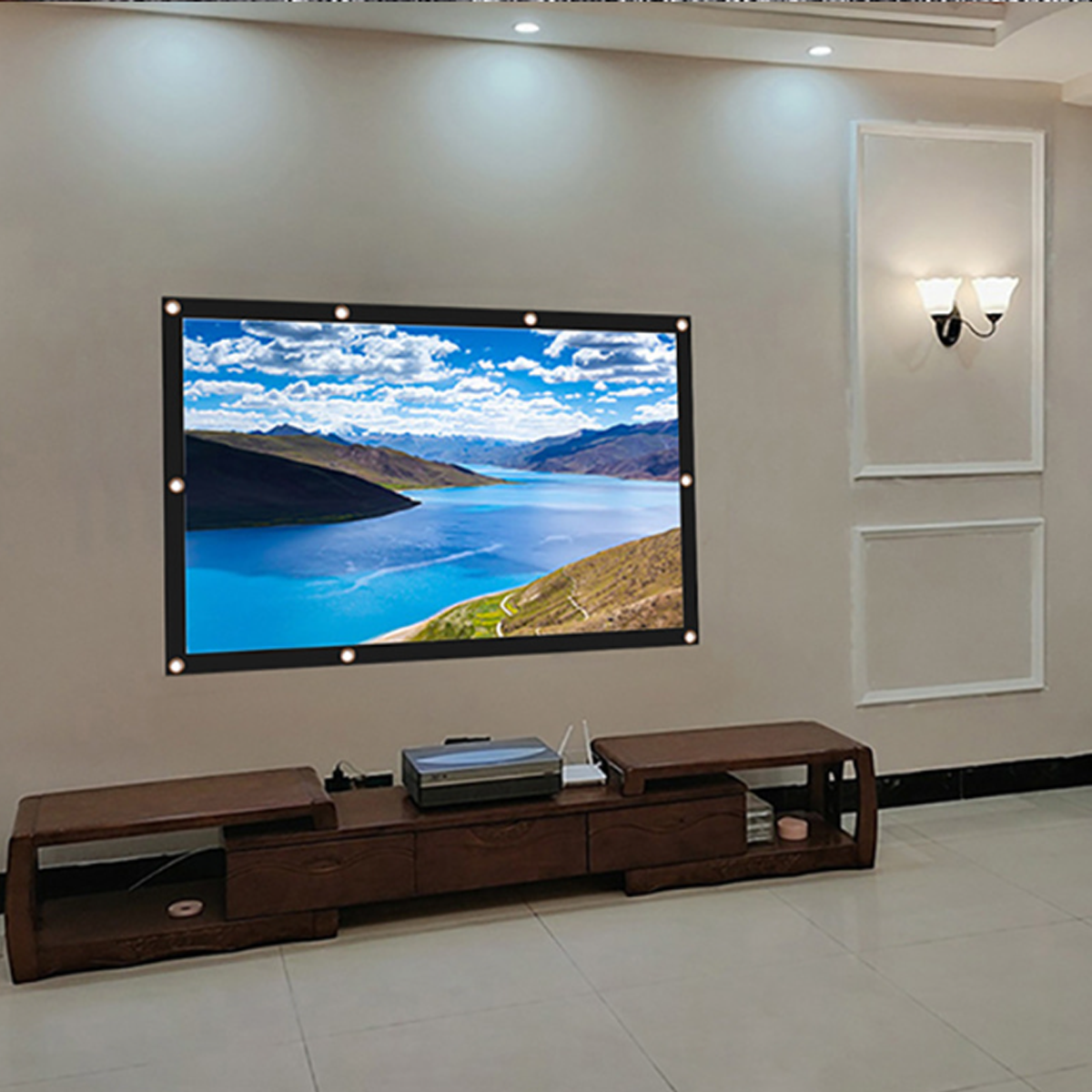 Eine Projektorleinwand mit See und Bergen. Ein Projektor und ein Holztisch darunter.