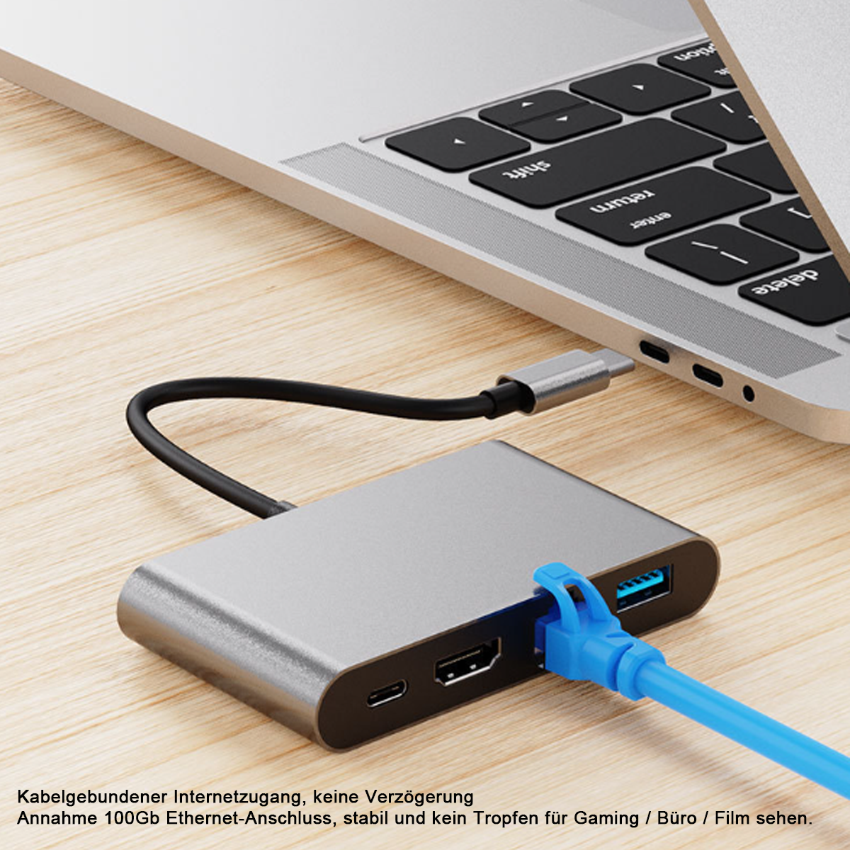 Ein silberner USB-Hub mit einem blauen Ethernet-Kabel. Im Hintergrund ist ein Laptop teilweise zu sehen.