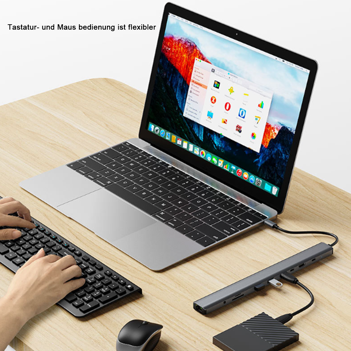 Laptop mit externer Tastatur, Maus und Hub. Der Bildschirm zeigt einen Desktop. Holztisch.
