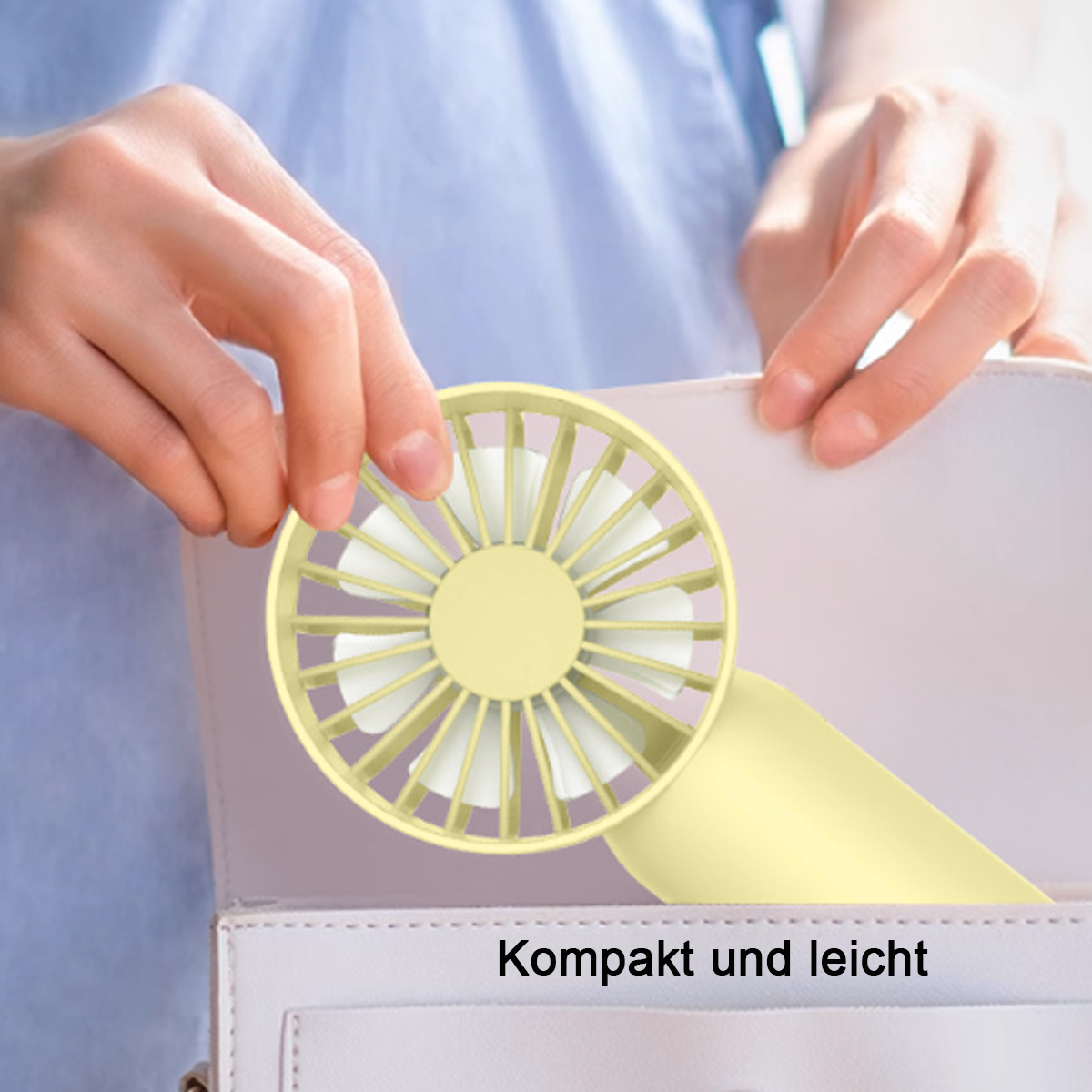 Eine Person hält einen gelb-weißen Handventilator in einer weißen Handtasche.