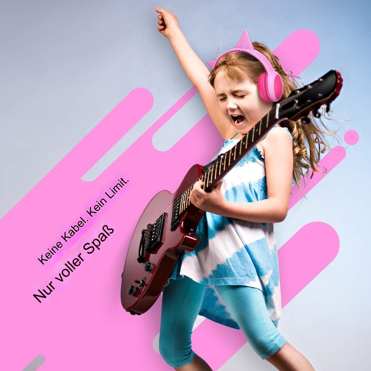 Junges Mädchen spielt E-Gitarre mit rosa Kopfhörern auf pinkfarbenem Hintergrund.