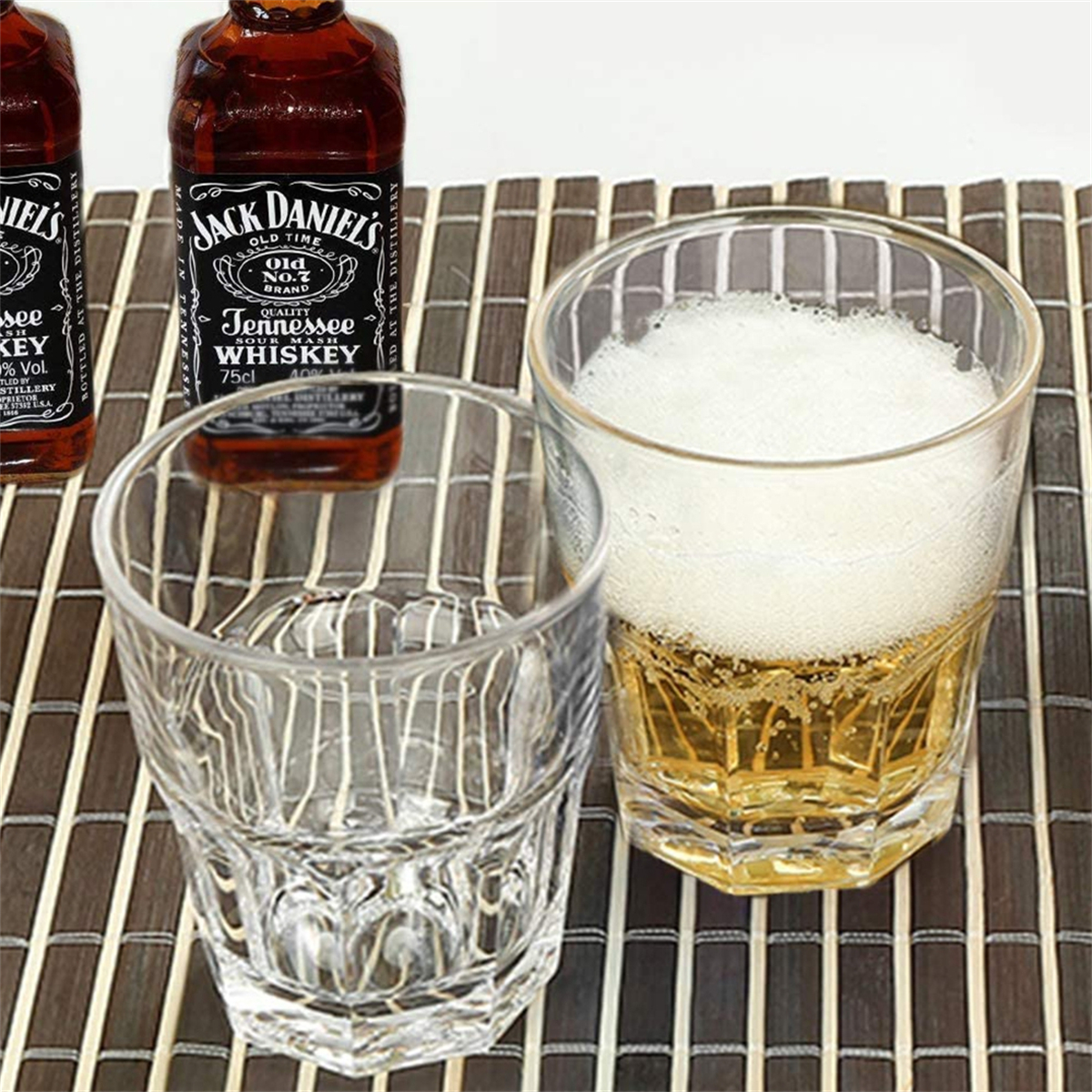 Zwei Gläser mit Bier und eine kleine Jack Daniel's Flasche auf einer Bambusmatte.