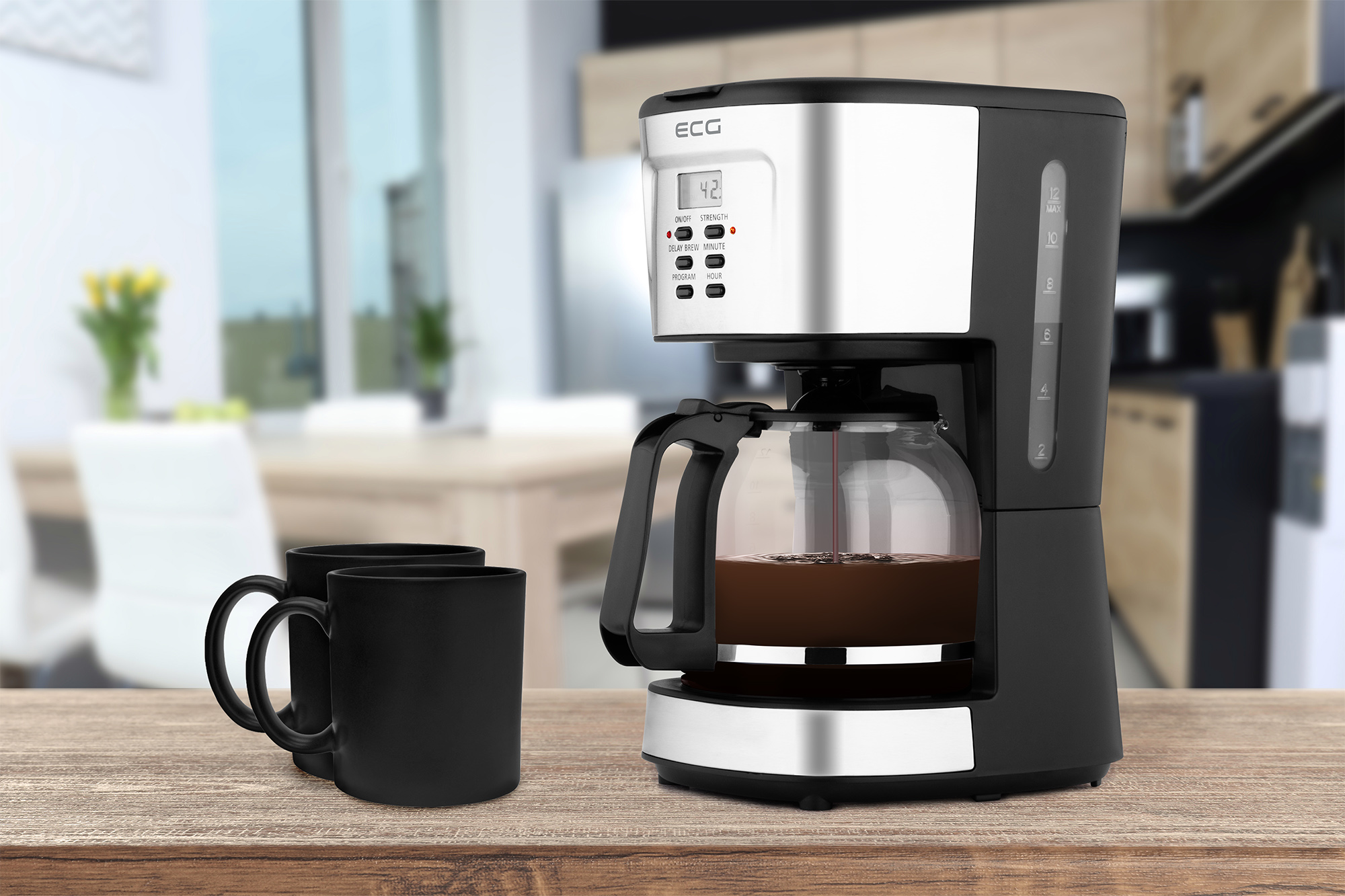 Kaffeemaschine mit Tassen auf Holztisch. Hintergrund zeigt Essbereich.