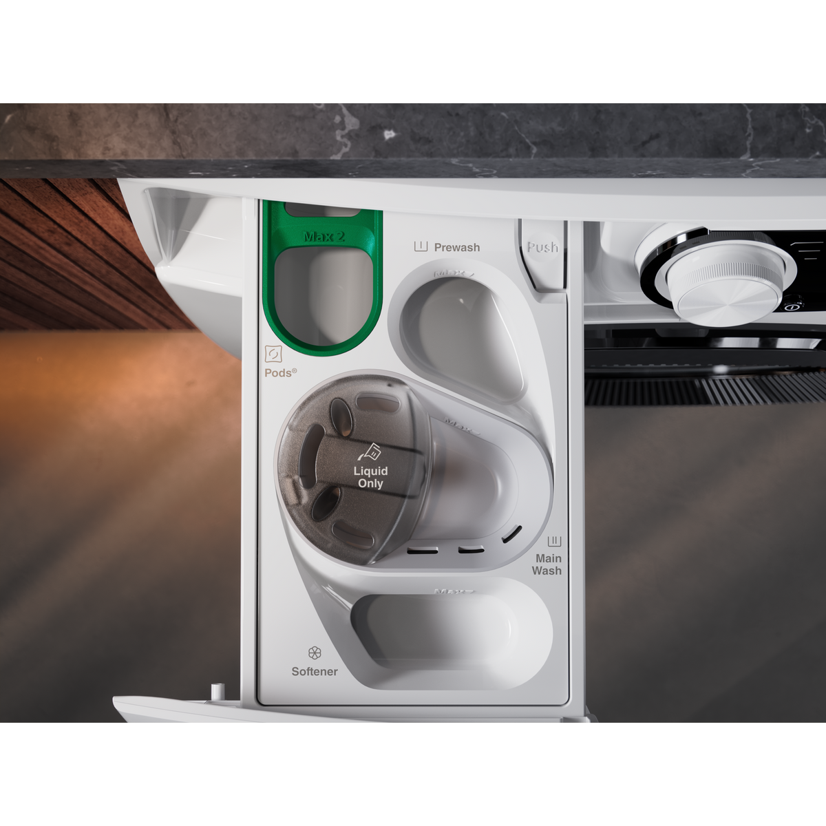 Otwarta biała szuflada na detergent do pralki z przegródkami.