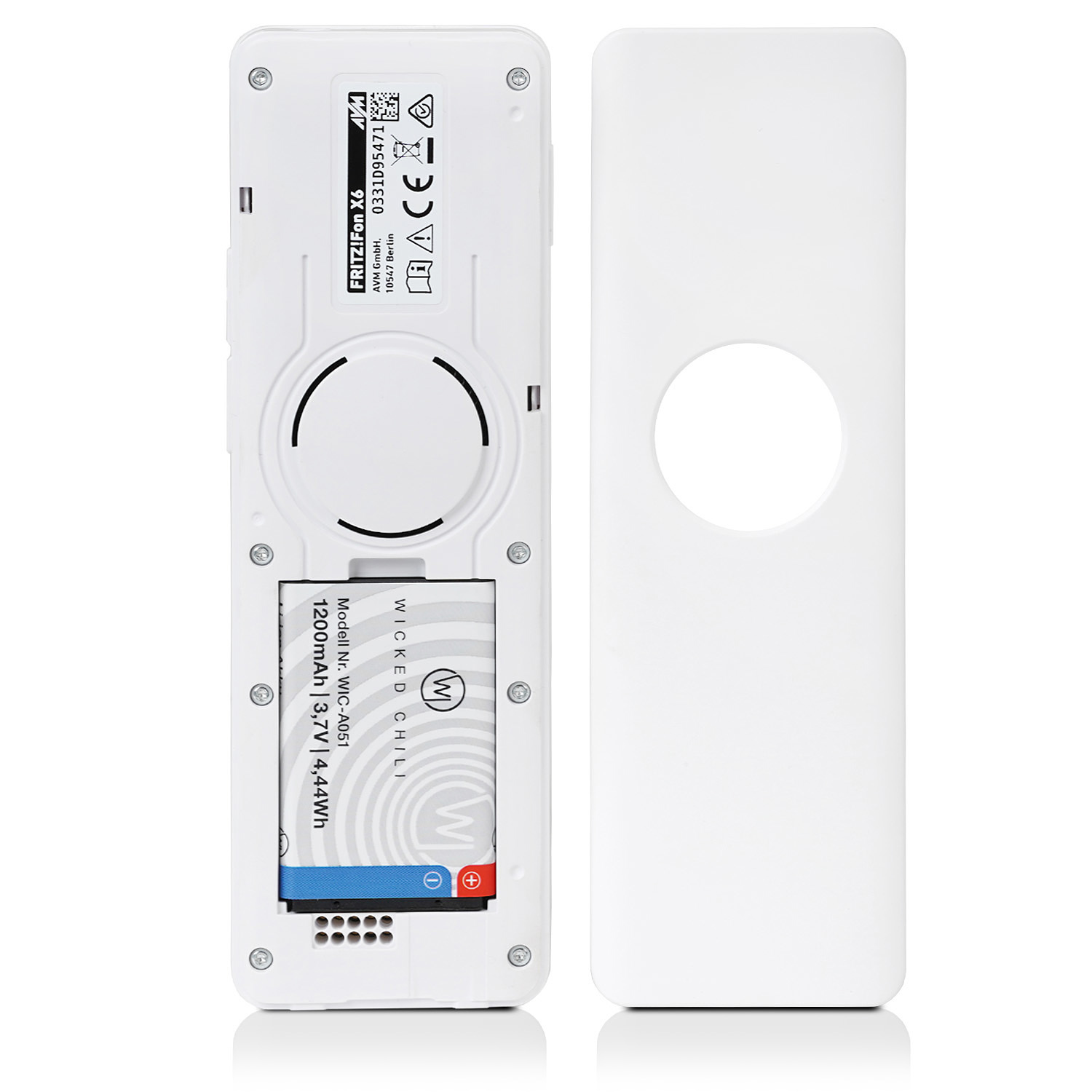 Ein weißes Gerät mit Batterie, Etiketten und einer kreisförmigen Öffnung. Die Abdeckung ist separat.