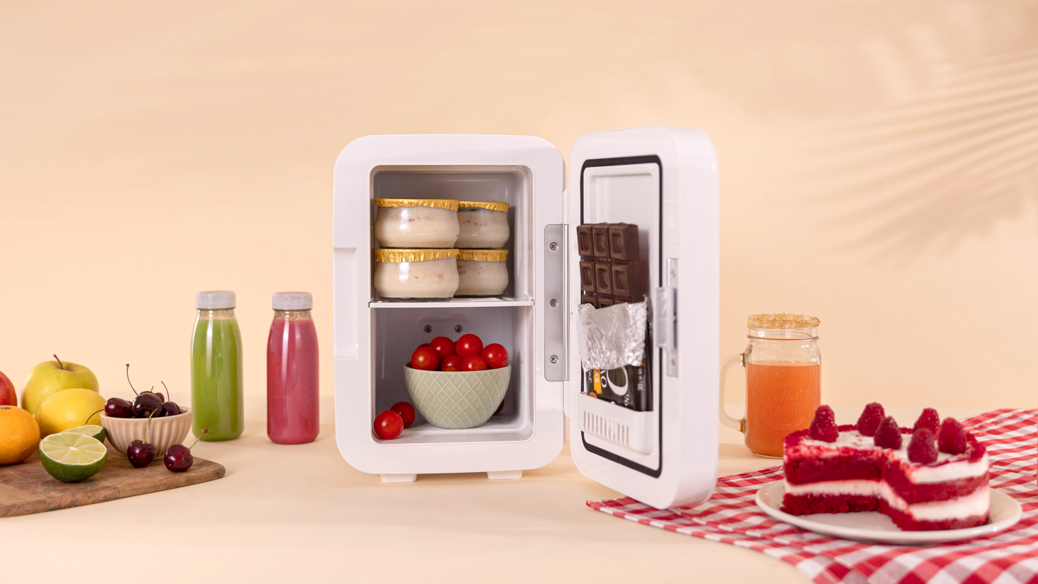 Un mini refrigerador abierto, mostrando comida y bebidas. También hay comida en la mesa.