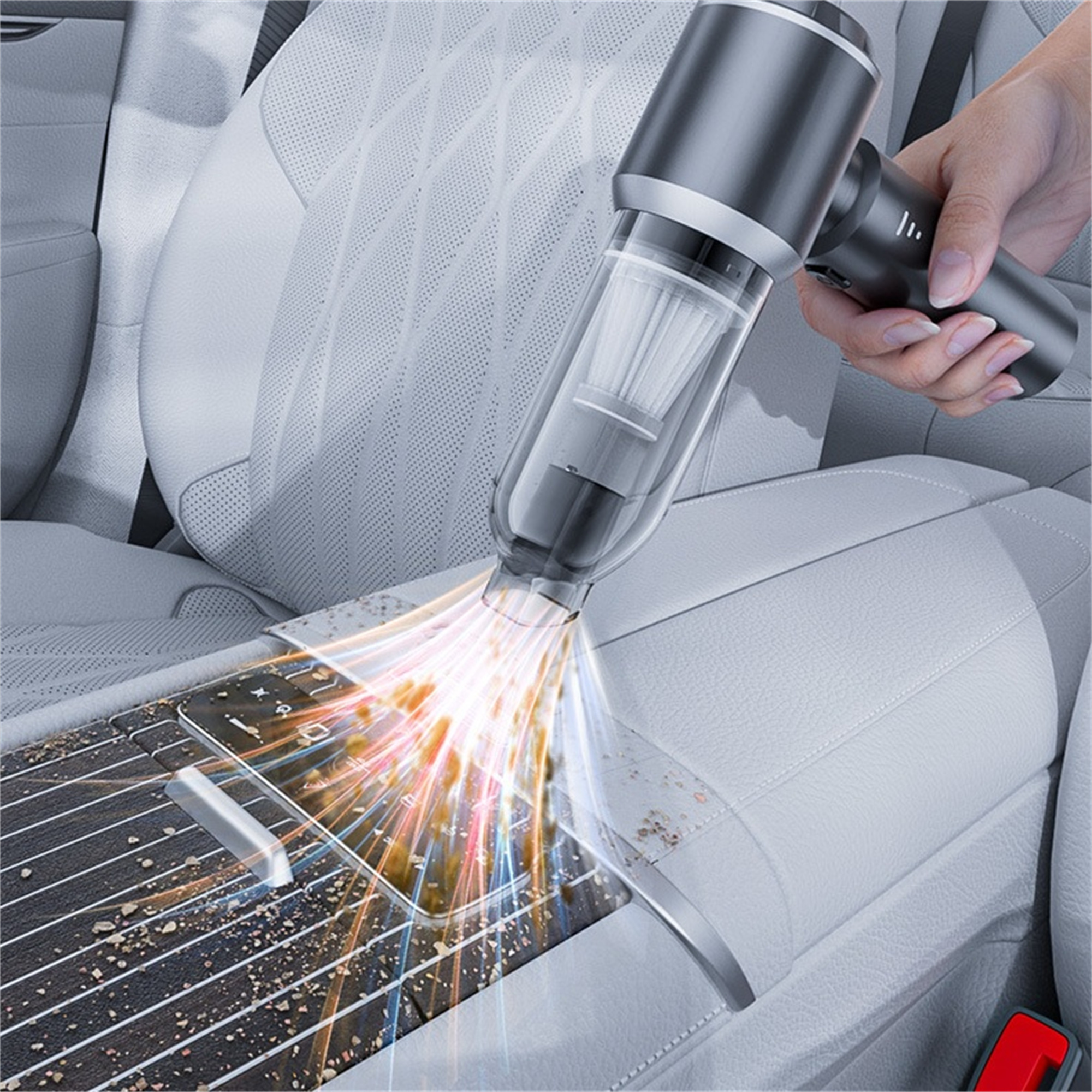 Ein Handstaubsauger reinigt die Konsole eines Autos, Staub wird aufgesaugt. Lichtstrahlen gehen von der Düse aus.