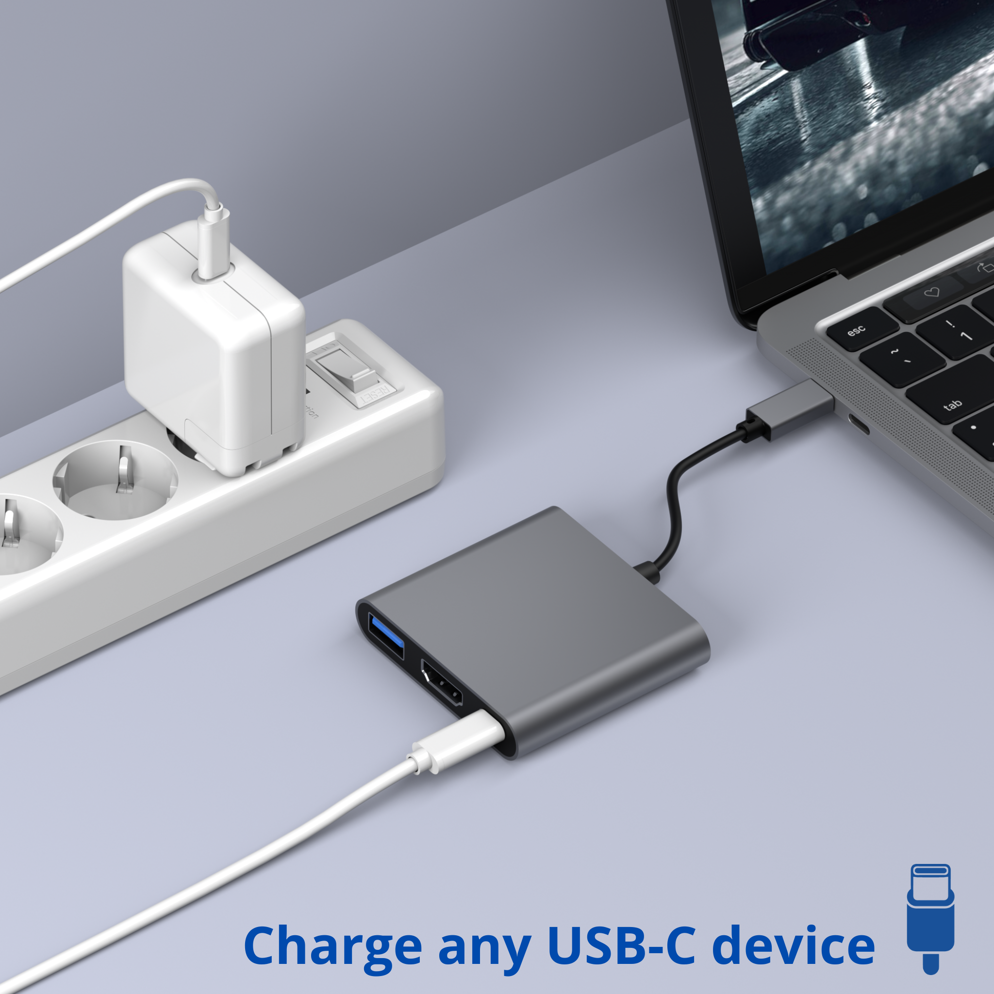 Un ordinateur portable est connecté à un hub USB-C gris avec un adaptateur secteur blanc.