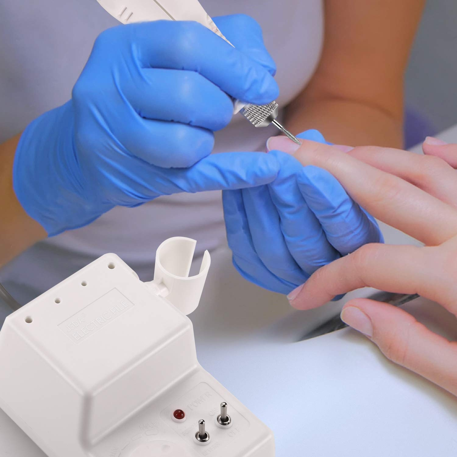 Hände in blauen Handschuhen bearbeiten einen Fingernagel mit einem weißen Maniküre-Werkzeug und rotem Licht.