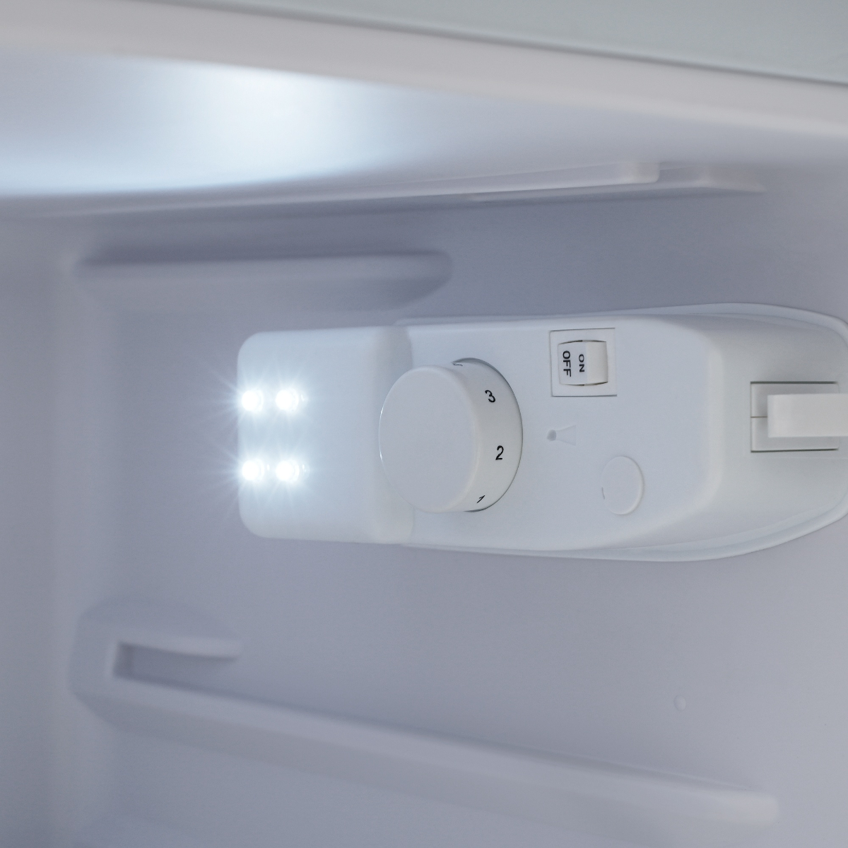 Nahaufnahme eines weißen Bedienfelds im Kühlschrank mit Licht und nummerierten Einstellungen.