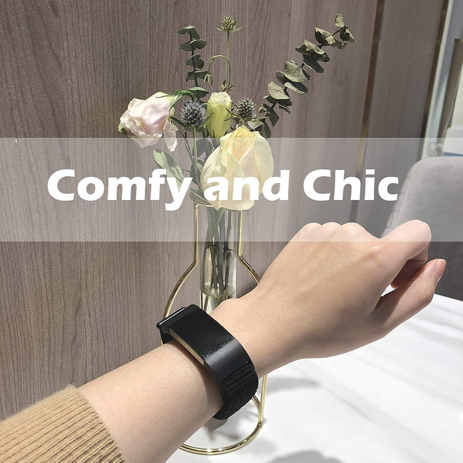 Eine Person trägt ein schwarzes Smartband, im Hintergrund eine Blumenvase.