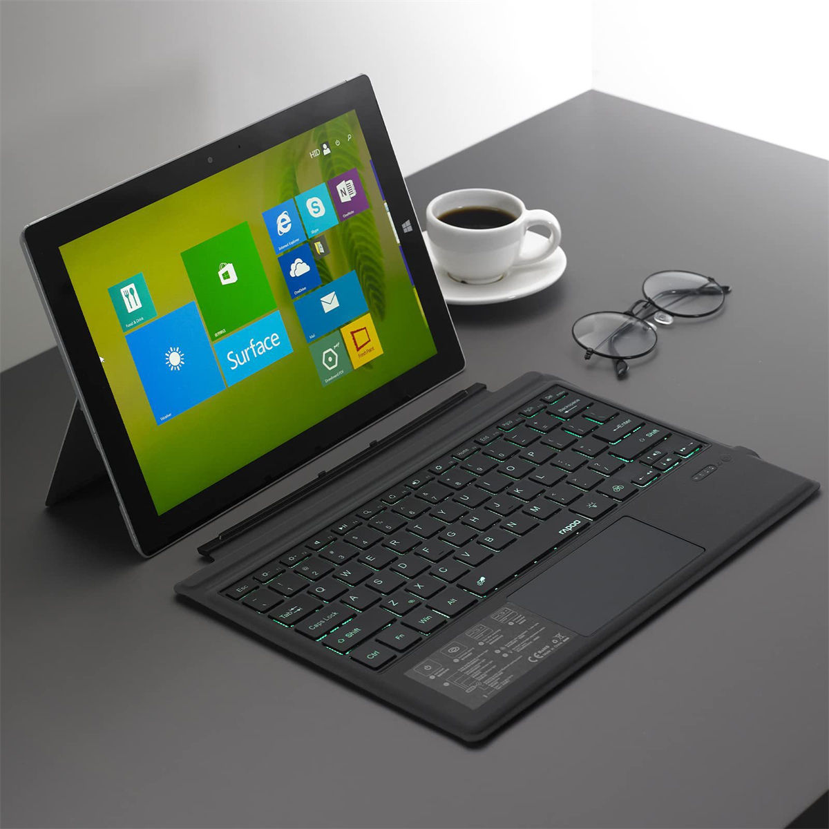 Tablet mit Tastatur und einer Tasse Kaffee. Der Hintergrund ist ein Schreibtisch.