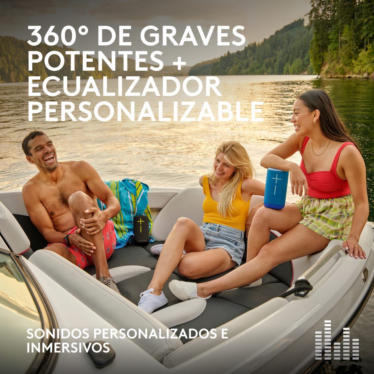 Trzy osoby na łodzi, trzymające niebieskie głośniki, uśmiechnięte. Jezioro i drzewa w tle.