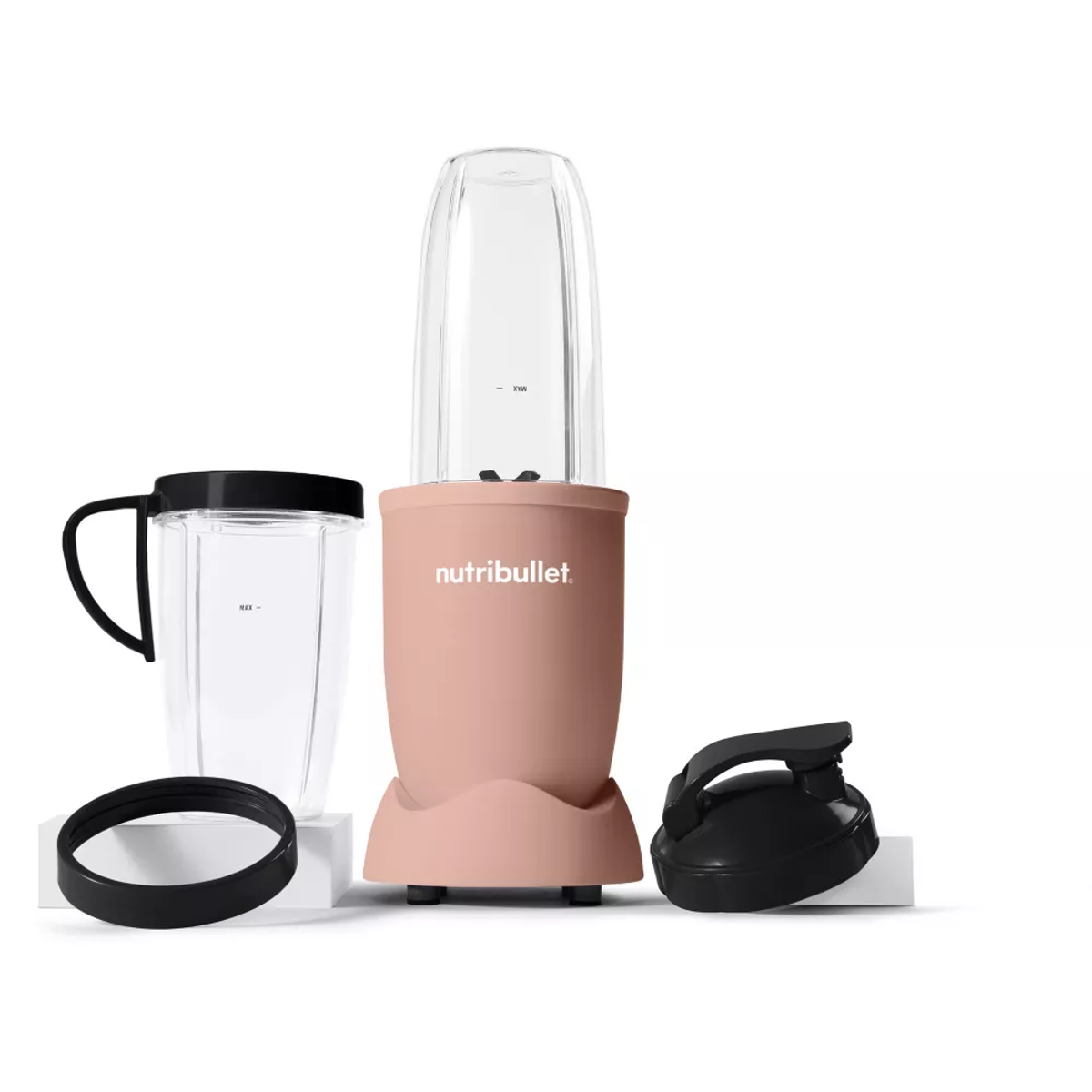 Różowy blender Nutribullet z przezroczystym kubkiem, czarną pokrywką i dodatkowymi częściami.