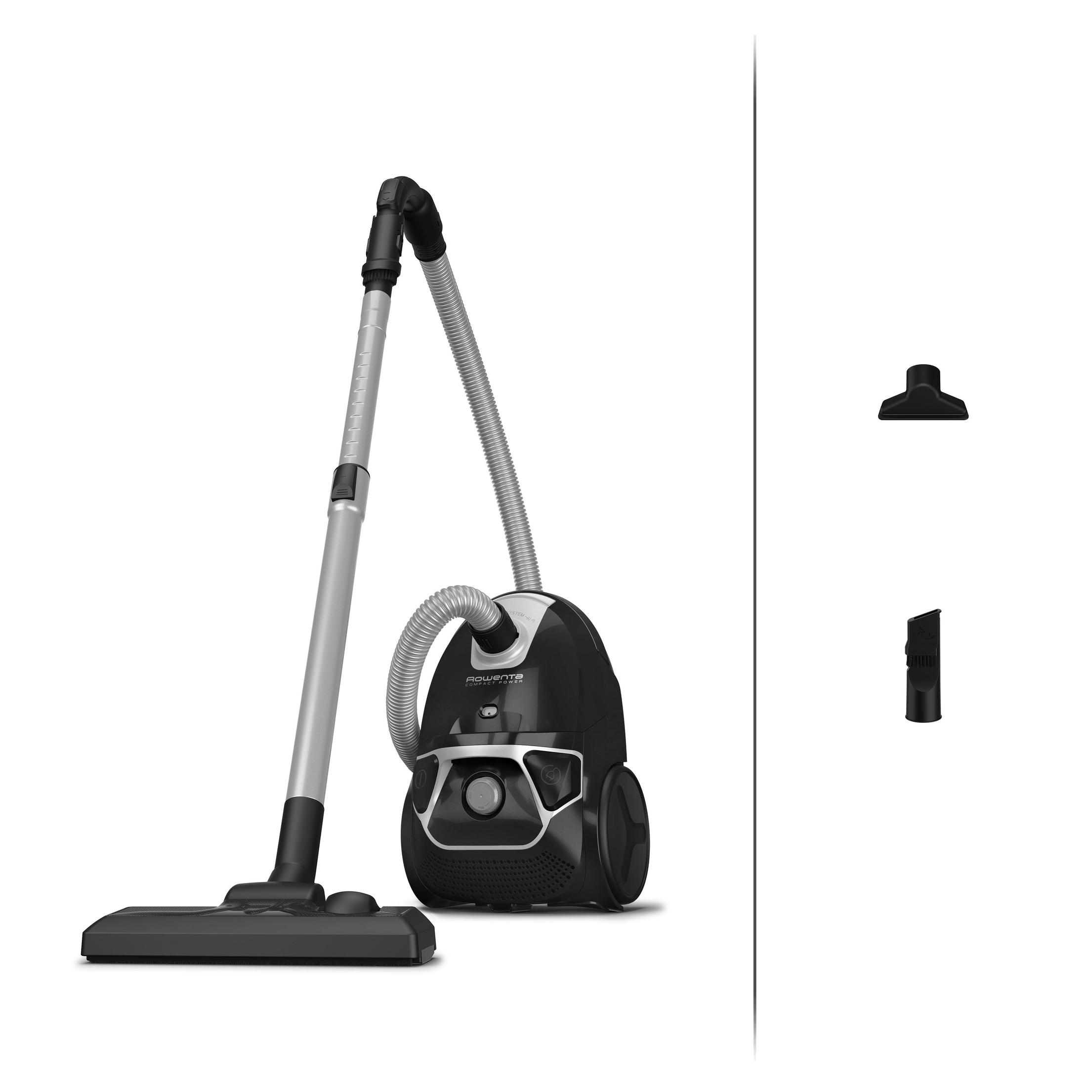 Aspirateur noir avec un tube et un tuyau argentés. Buses supplémentaires à droite.