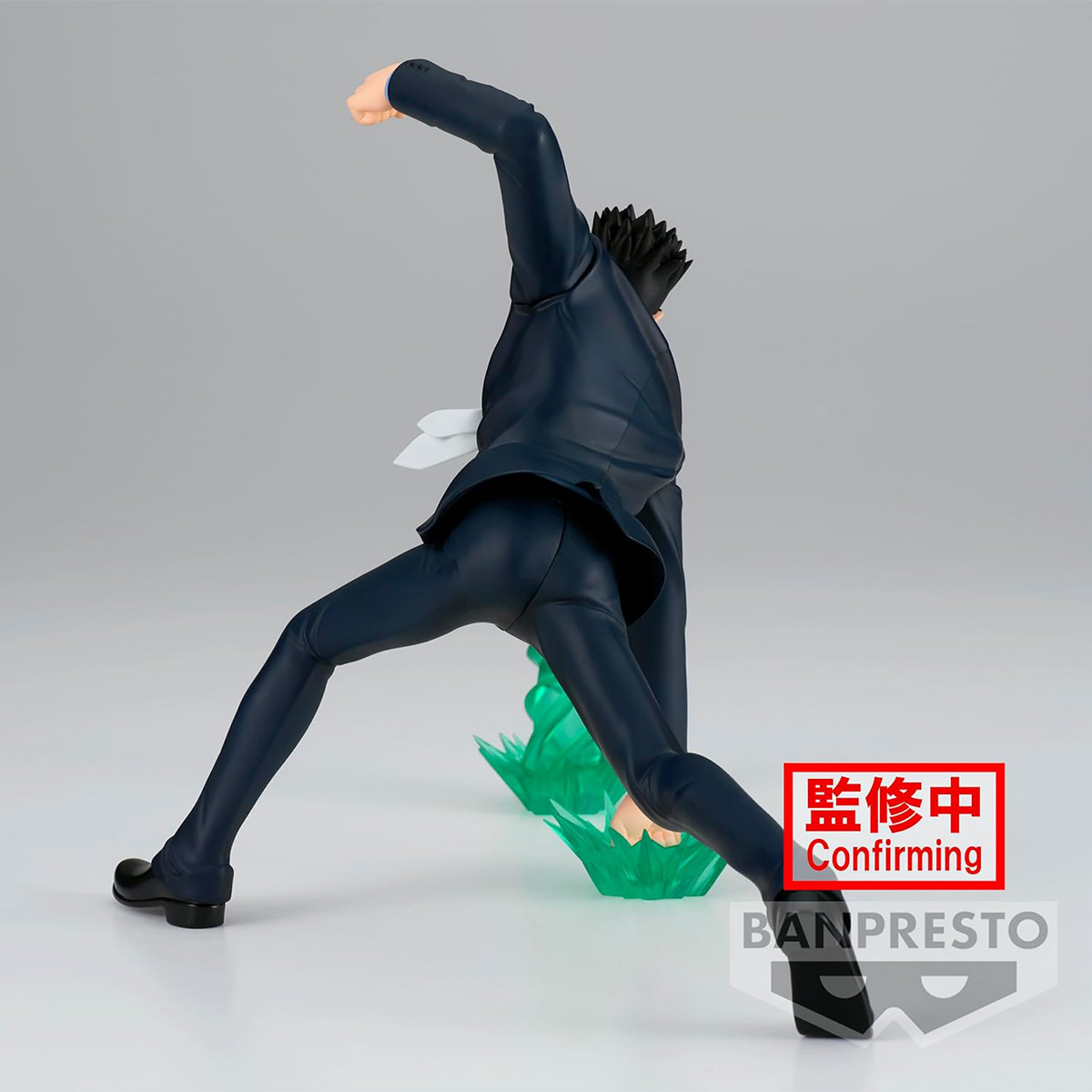 Figura de anime en pose dinámica, traje oscuro, extendiendo un puño. Base verde, fondo de estudio.