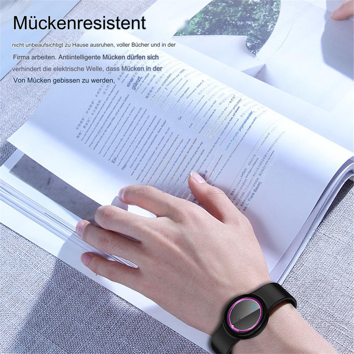 Eine Person trägt eine Uhr und liest ein Buch. Die Uhr hat ein schwarzes Armband und einen pinkfarbenen Mittelteil.