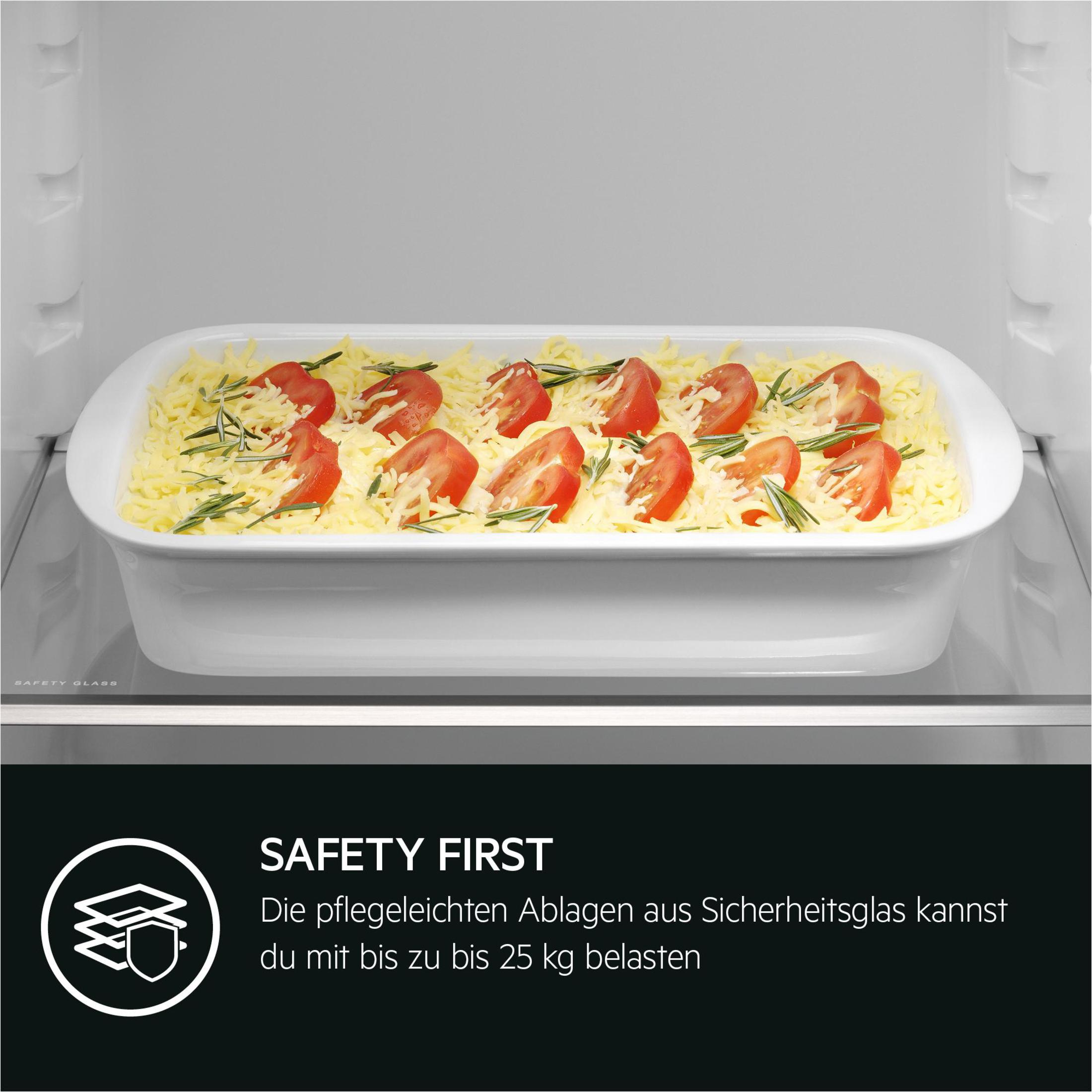 A white baking dish with tomatoes and cheese inside a refrigerator.