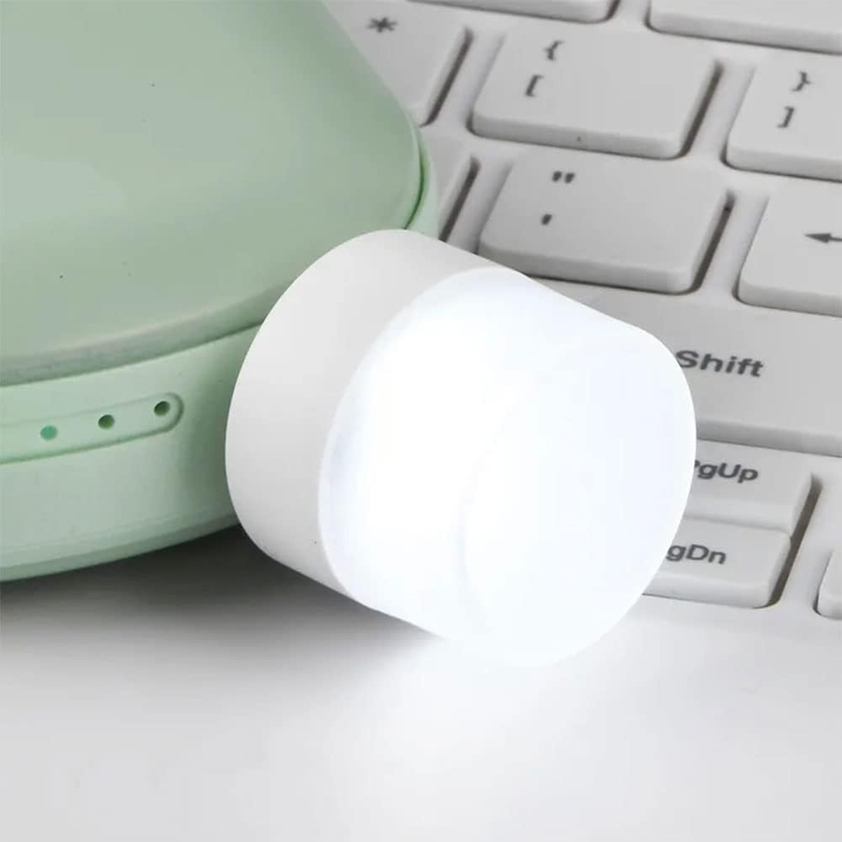 Weiße leuchtende LED-Lampe auf einer Tastatur und einem grünen Gerät.