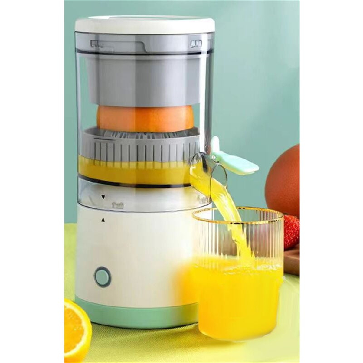 Entsafter mit Orange, Saft fließt in ein Glas. Andere Früchte im Hintergrund.