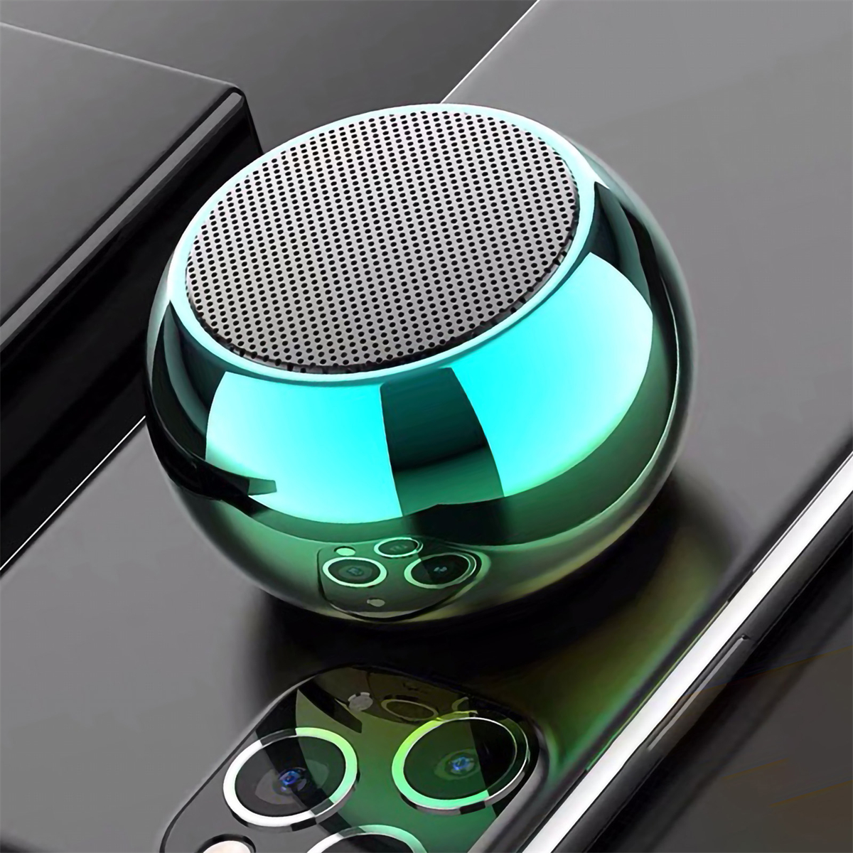 Ein kleiner, metallisch grüner, kugelförmiger Lautsprecher auf einem Telefon.