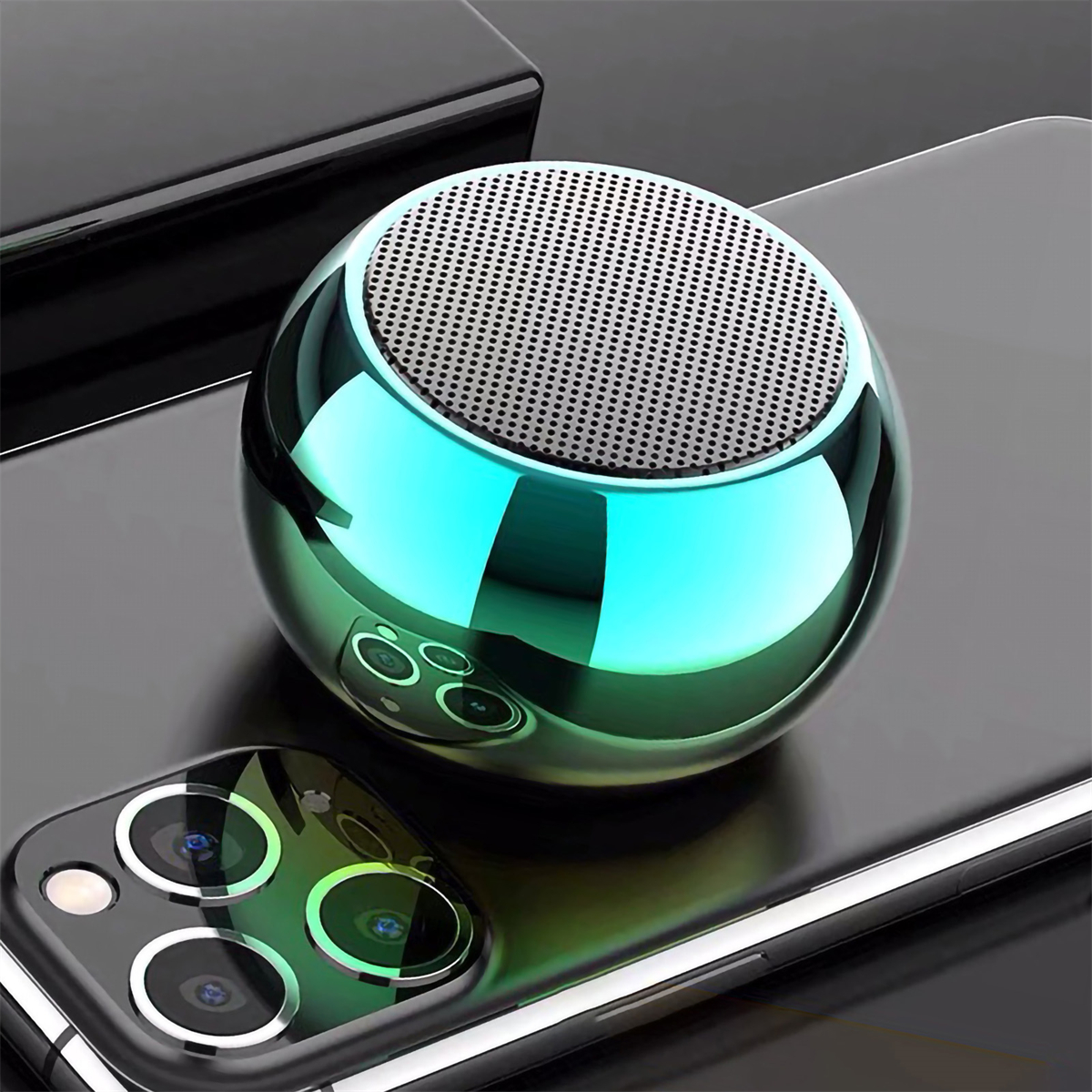 Ein glänzender, grüner, kugelförmiger Lautsprecher auf einem Telefon. Das Telefon hat eine Kamera. Der Lautsprecher ist metallisch.