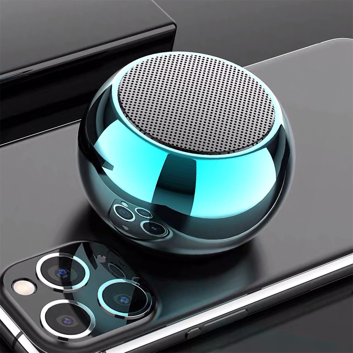 Blauer metallischer Kugel-Lautsprecher auf einem Telefon mit Kamera auf der Rückseite.