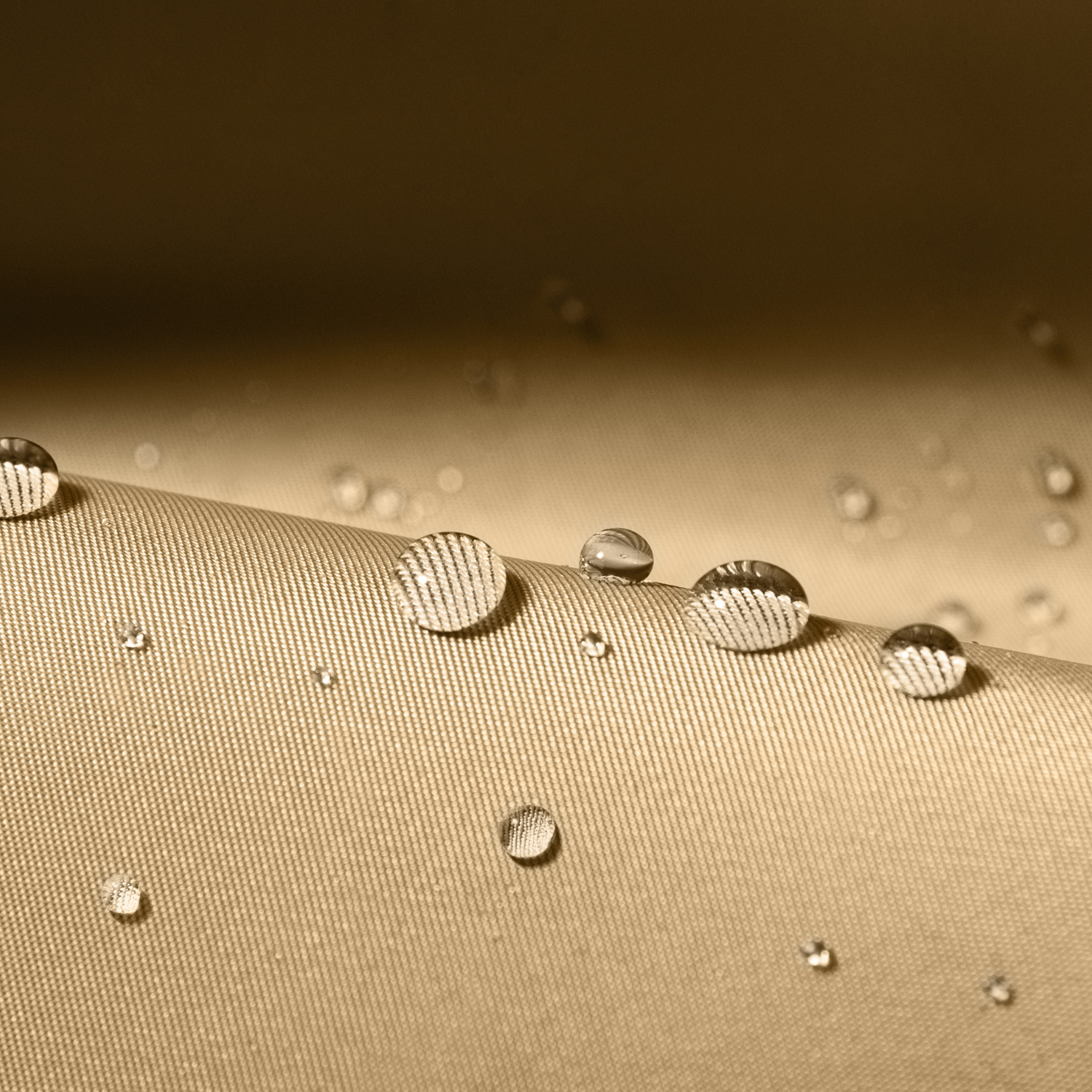 Primo piano di tessuto beige con gocce d'acqua. Il tessuto ha una trama tessuta.