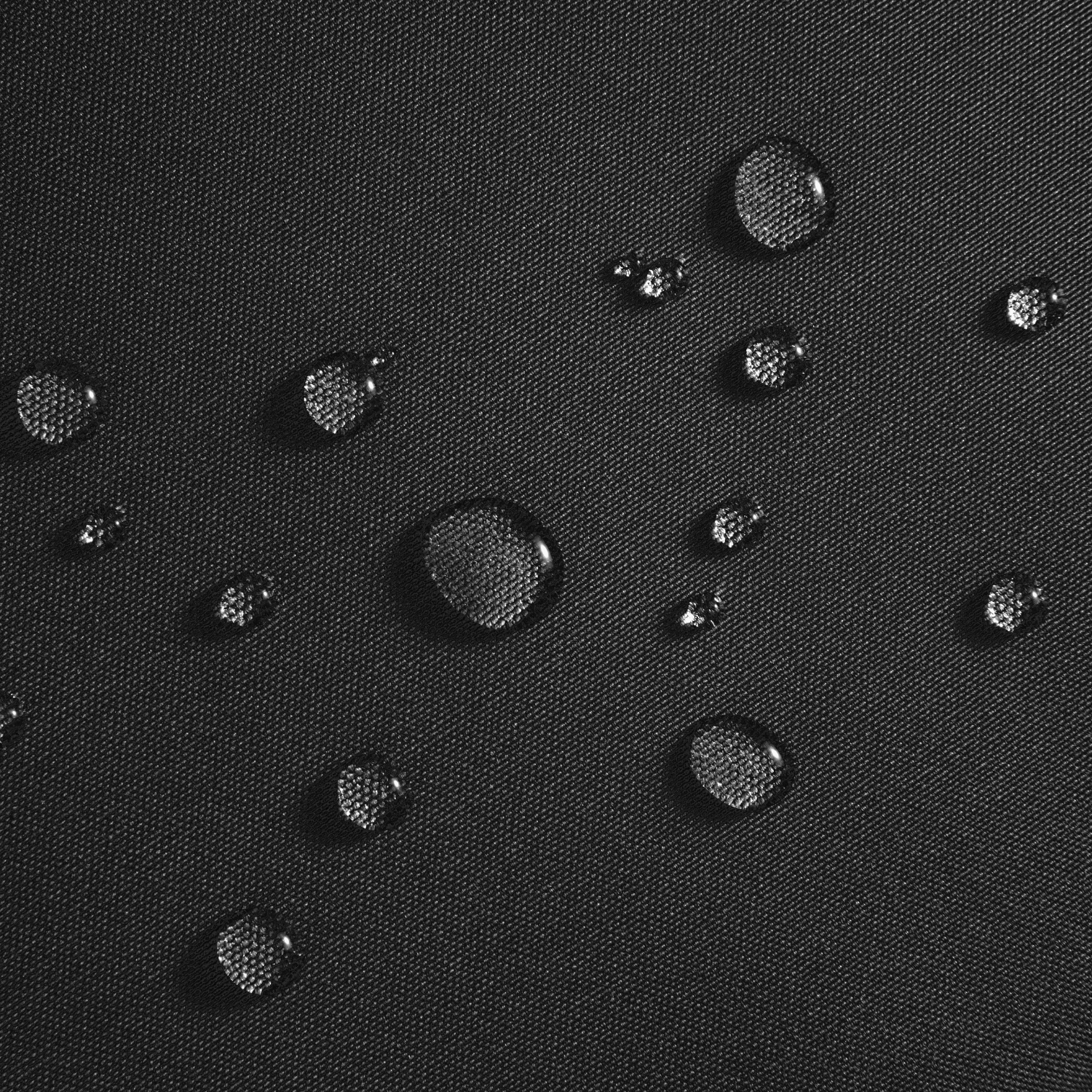 Primo piano di tessuto nero con goccioline d'acqua. Il tessuto ha una superficie strutturata.